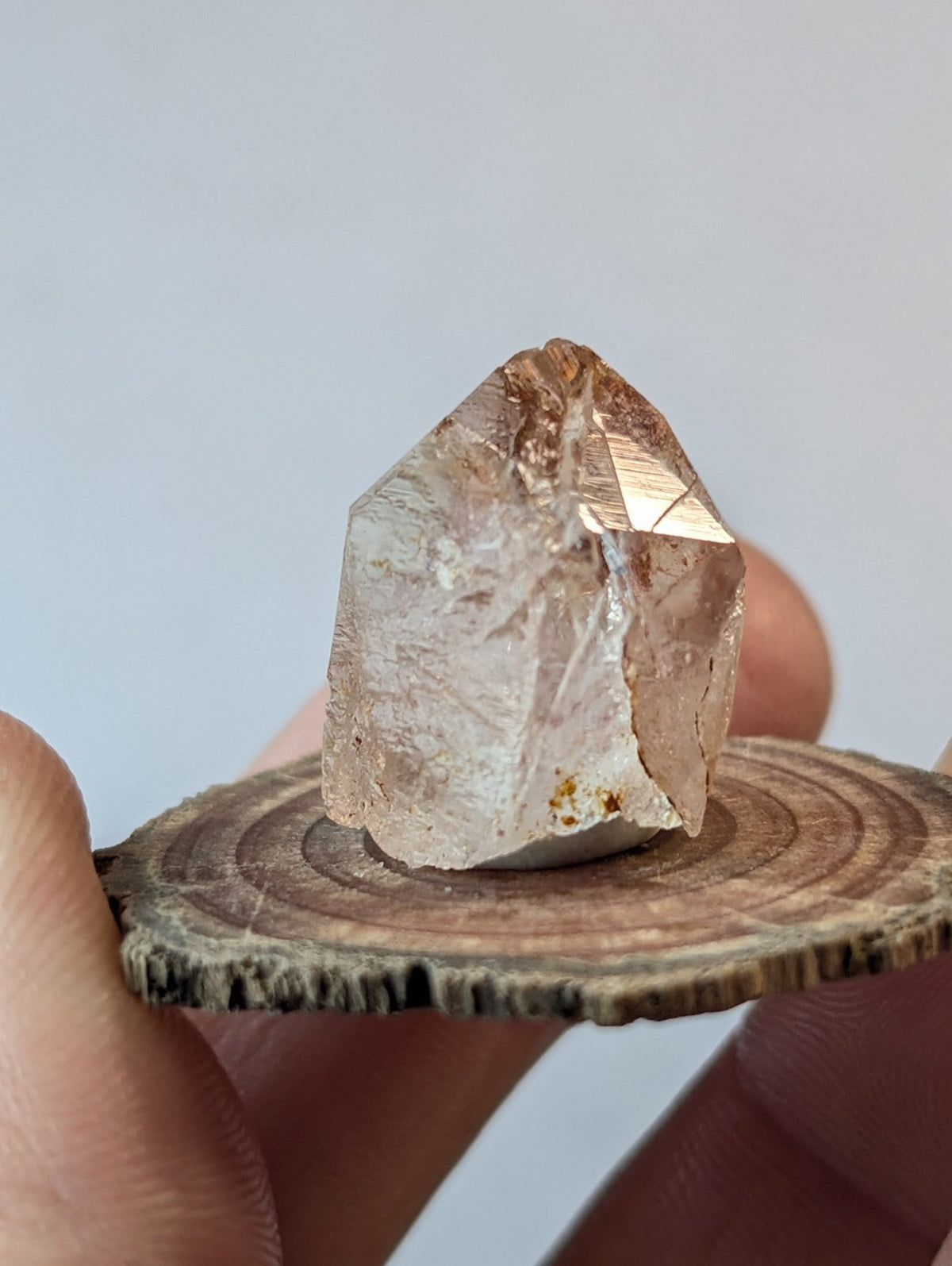 A translucent, brown-tinted quartz crystal with a pointed tip and visible internal striations.