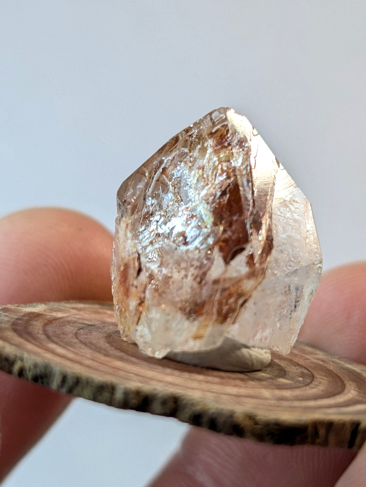 A translucent, faceted crystal with golden-brown inclusions and a shimmering surface.