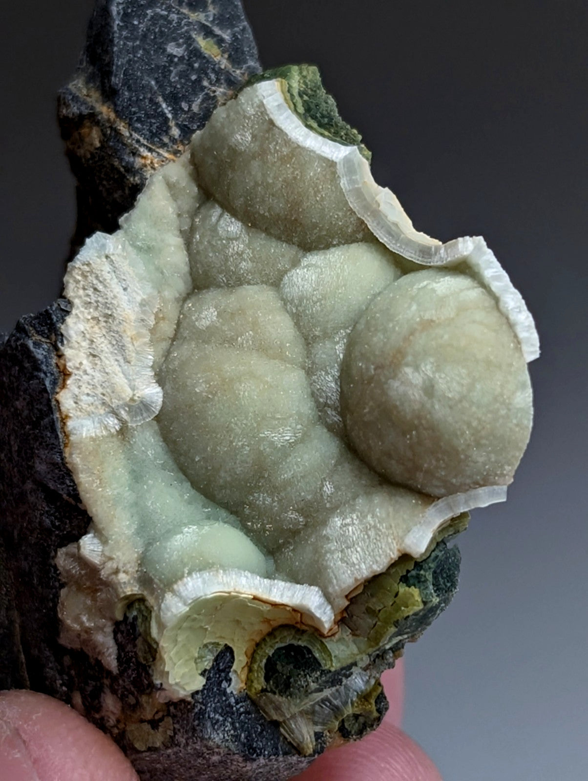 A pale green translucent uv reactive wavellite geode with bubble formations and white crystalline rim from arkansas usa