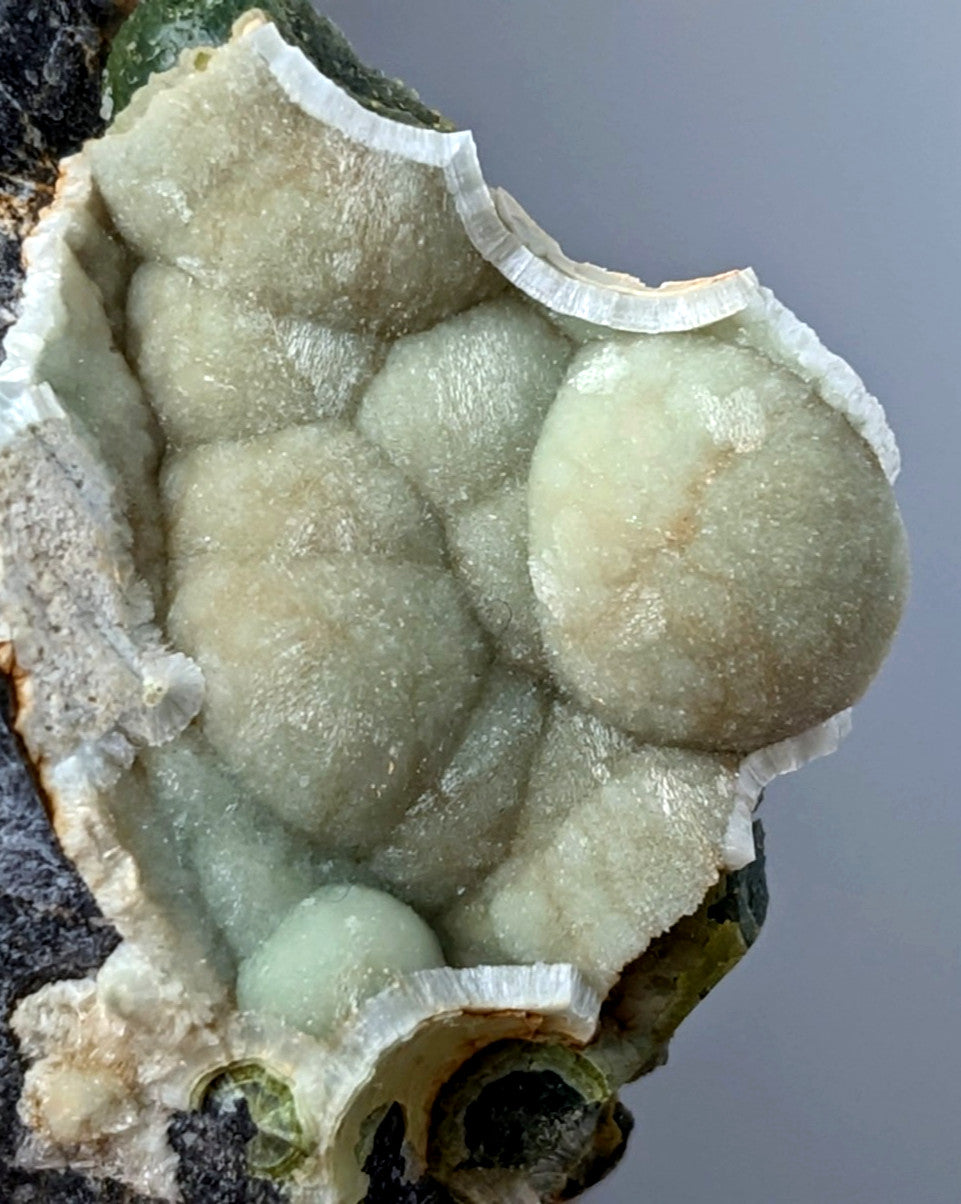 A pale green translucent wavellite geode with bubble-like crystals in a cracked white and dark matrix from mauldin mountain usa