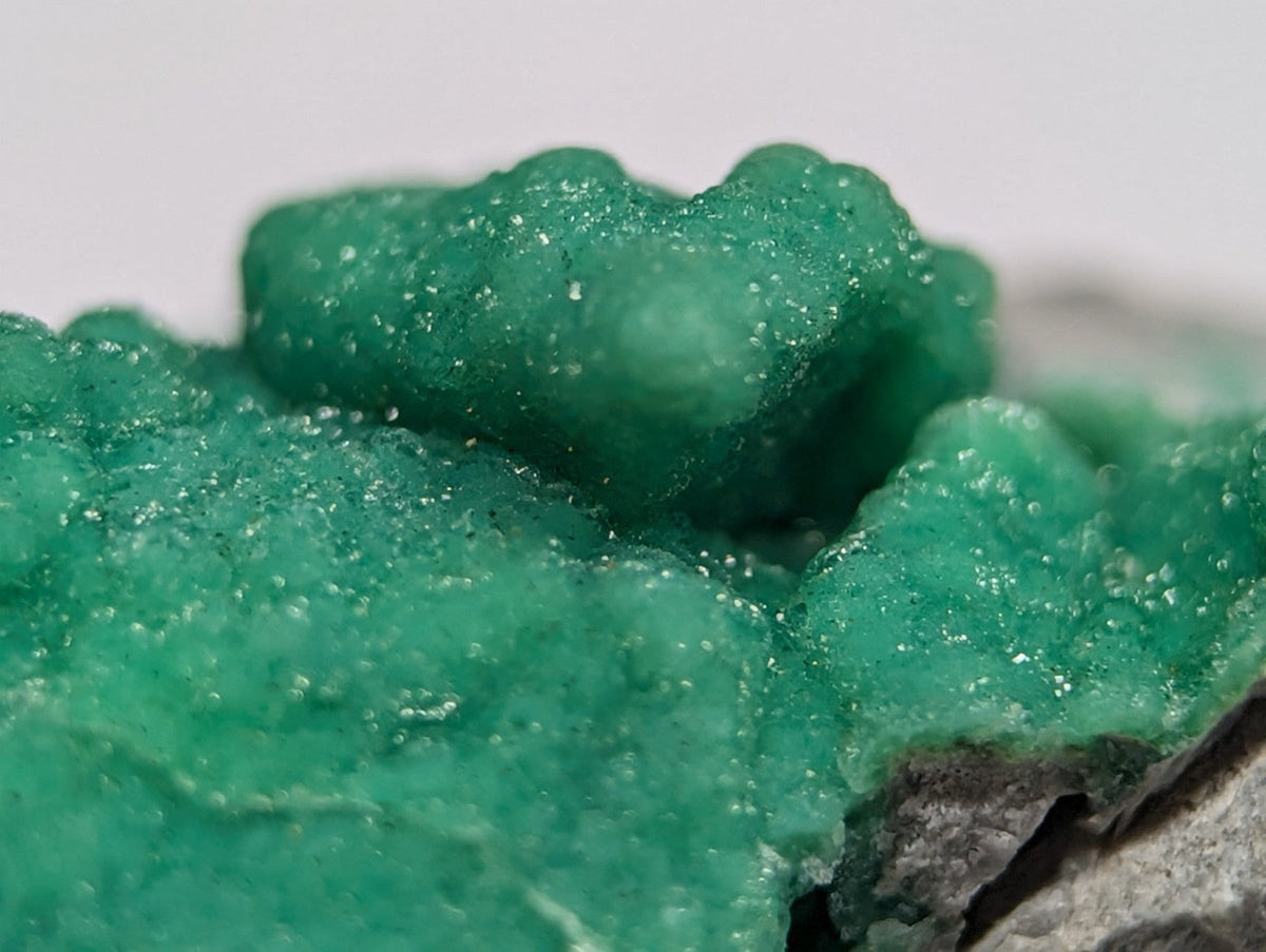 Vibrant green, crystalline mineral specimen with a textured, bubbly surface.