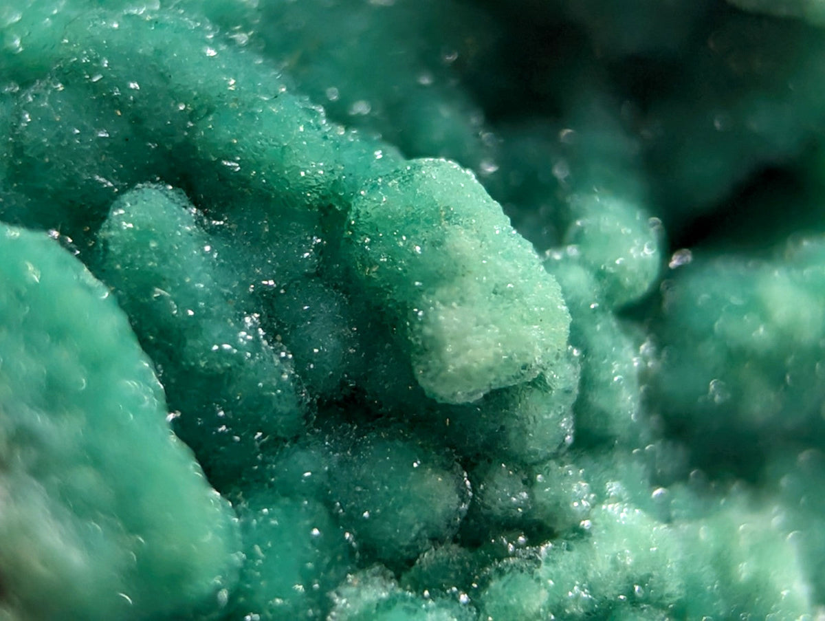 Vibrant teal-green copper carbonate mineral specimen with crystalline, textured surfaces.
