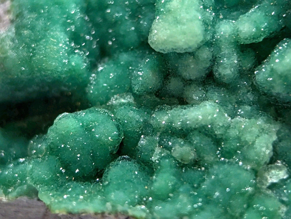 Vibrant emerald-green copper carbonate mineral formation with a crystalline, bubbly texture.