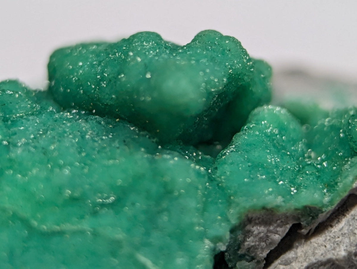 Vibrant emerald-green copper carbonate mineral specimen with a crystalline, bubbly texture.