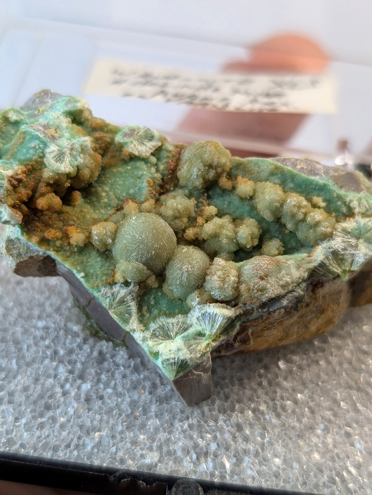 A striking green and yellow mineral specimen featuring rounded, clustered formations on a textured base.