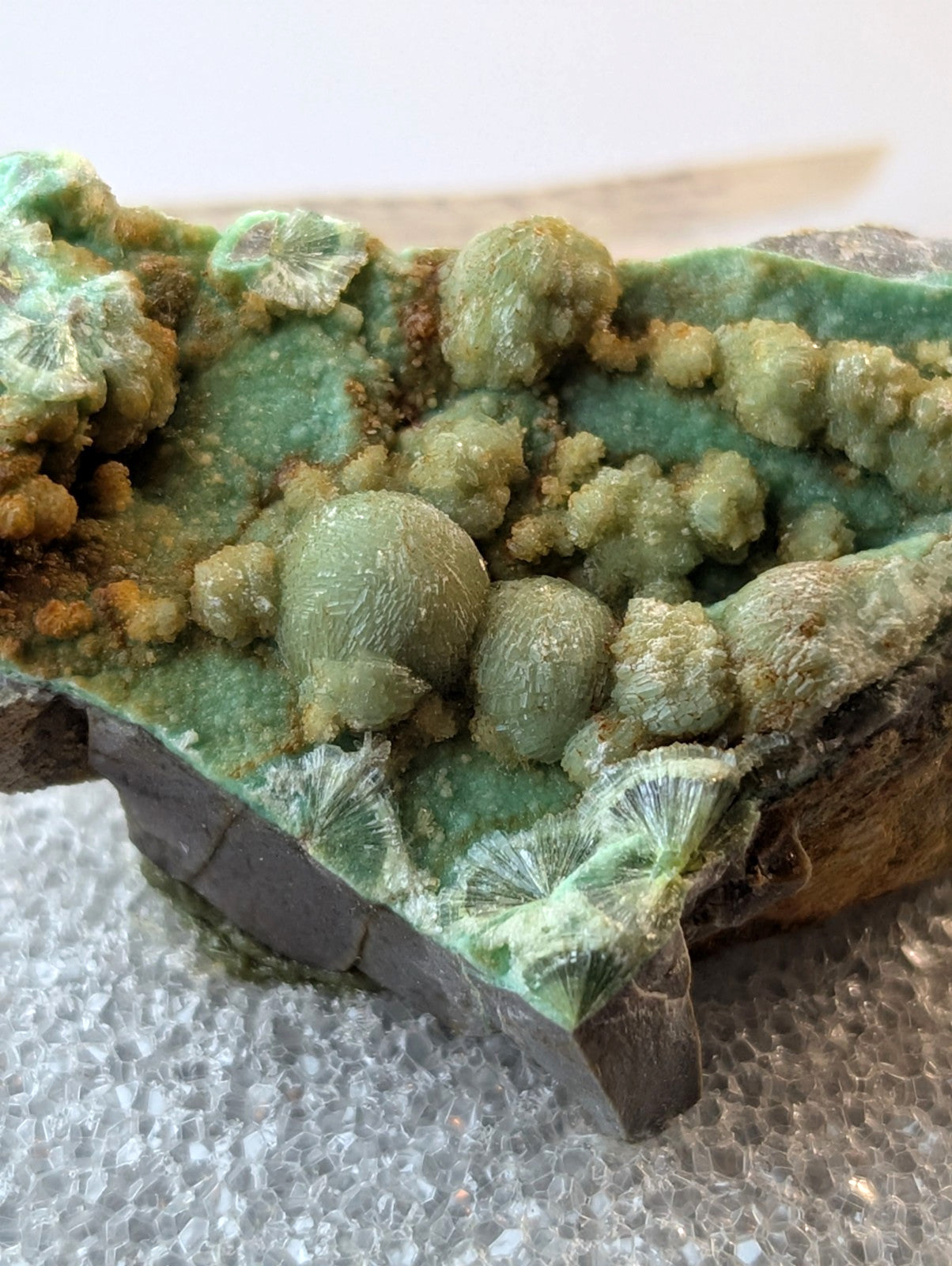A vibrant green malachite specimen with intricate, rounded crystalline formations and a textured surface.