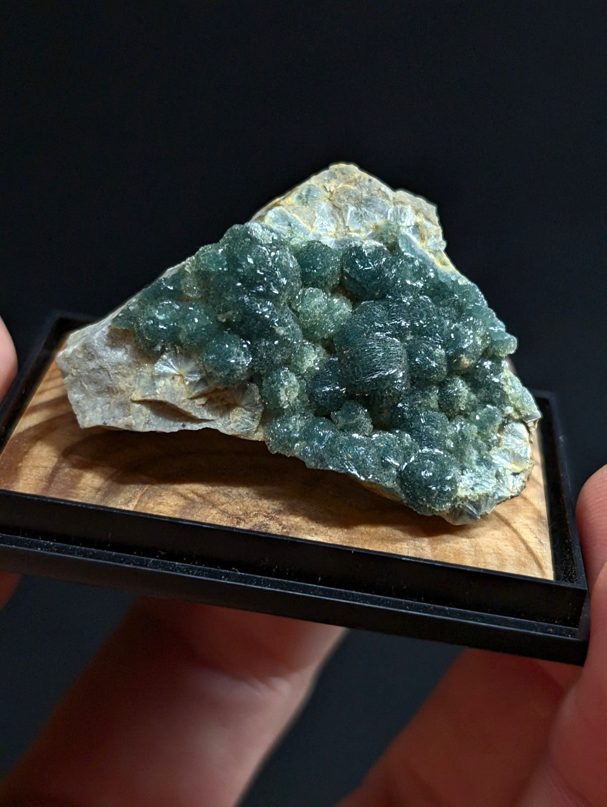 A striking green fluorite crystal cluster with a rough, earthy matrix base.