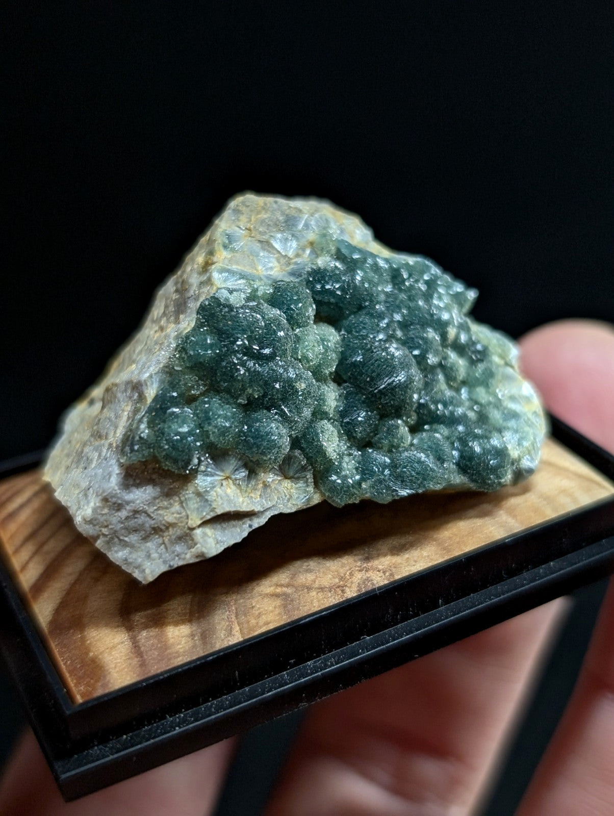 A green, crystalline mineral specimen with a rough, textured surface and translucent facets.