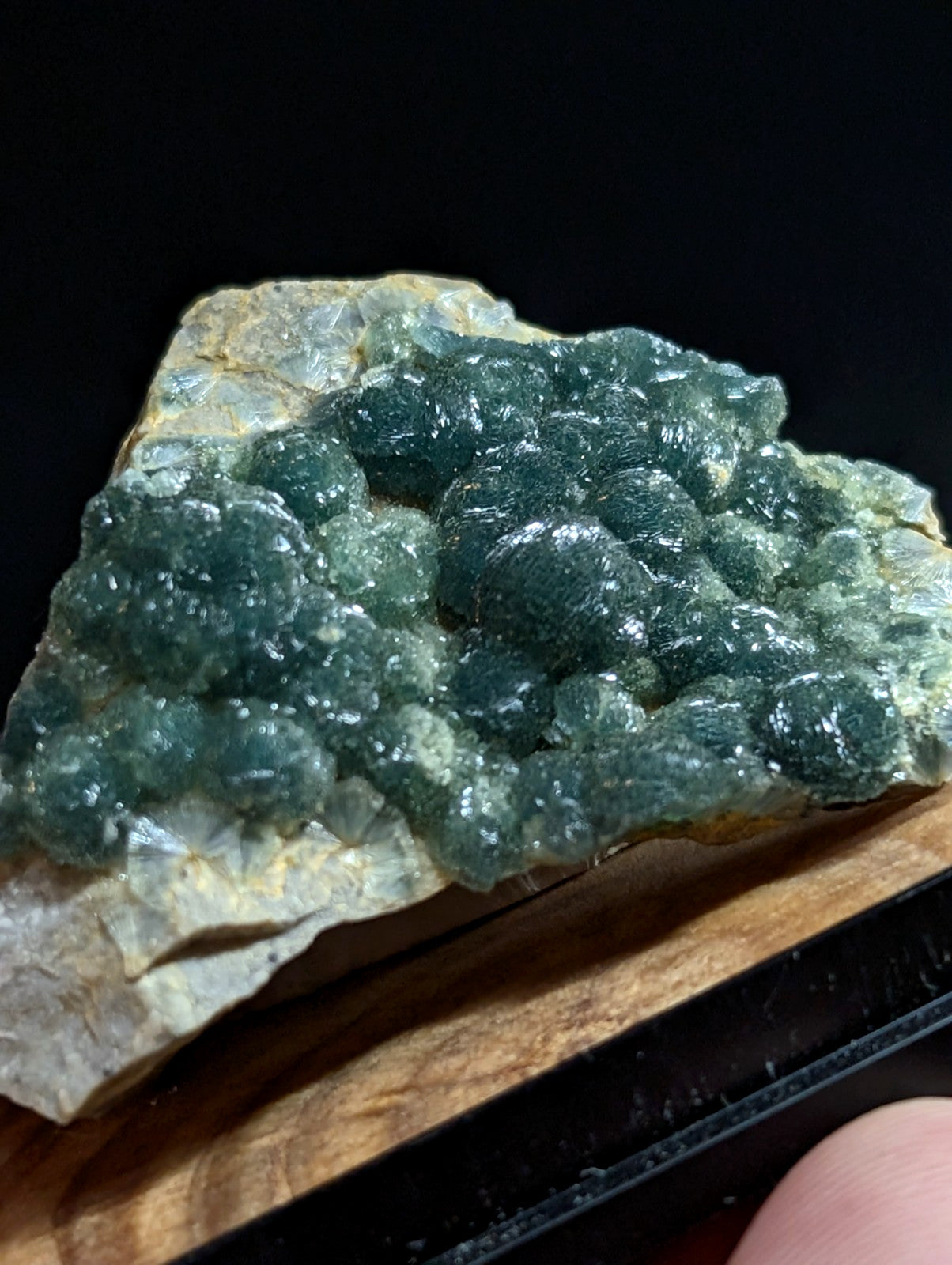 A striking green mineral specimen with a bumpy, crystalline surface and translucent quality.
