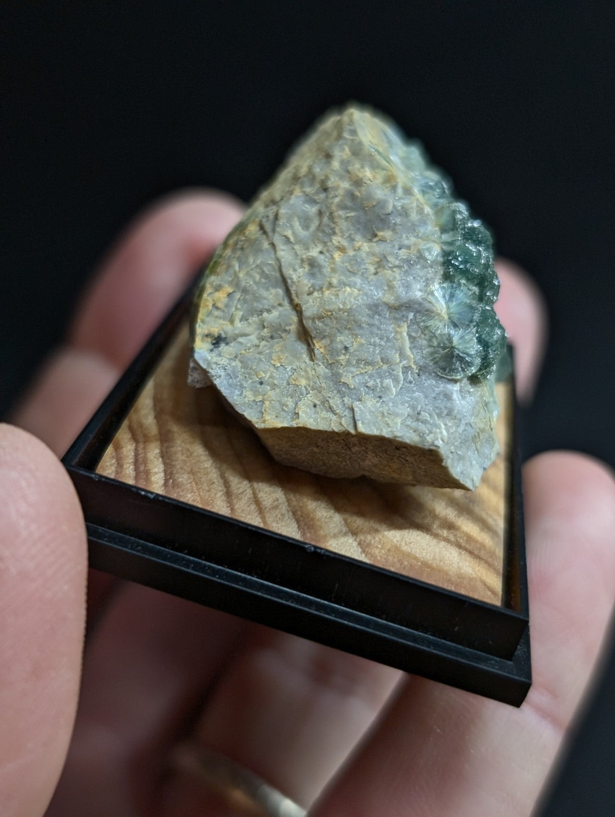 A rough, irregularly shaped piece of greenish-gray mineral with a translucent quality and visible crystalline texture.