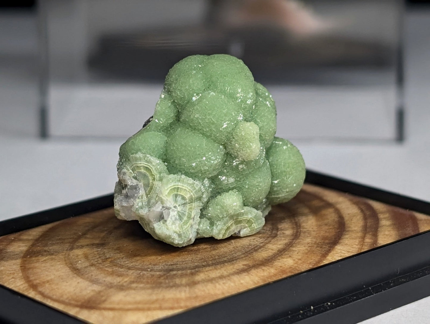 A vibrant green, bubble-like mineral specimen with a crystalline texture and layered patterns.