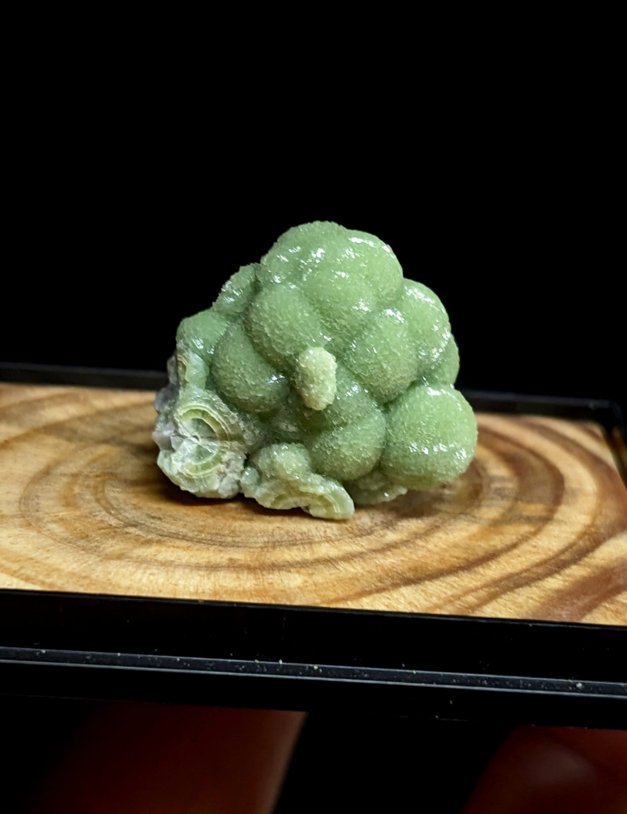A translucent green geode with a clustered, bubble-like formation.
