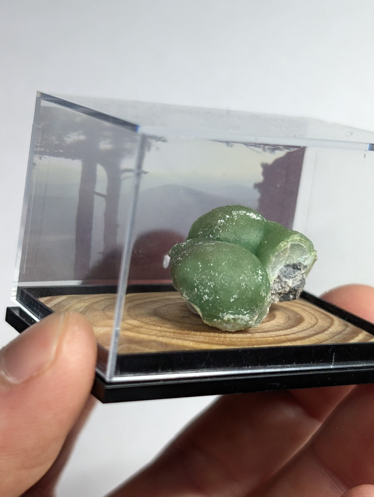 A smooth, translucent green mineral specimen with a slightly rough texture and subtle white veining.