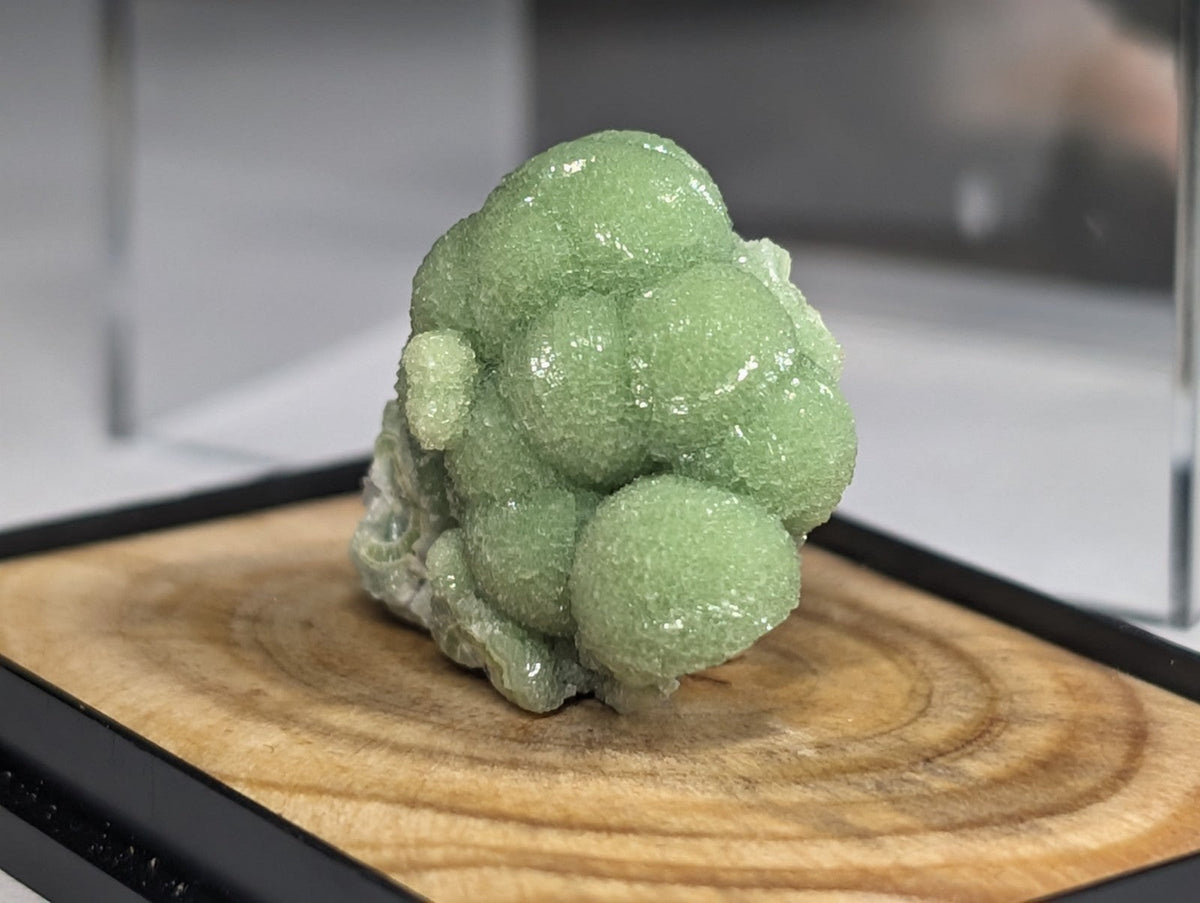 A translucent green mineral specimen with rounded, bubble-like formations.