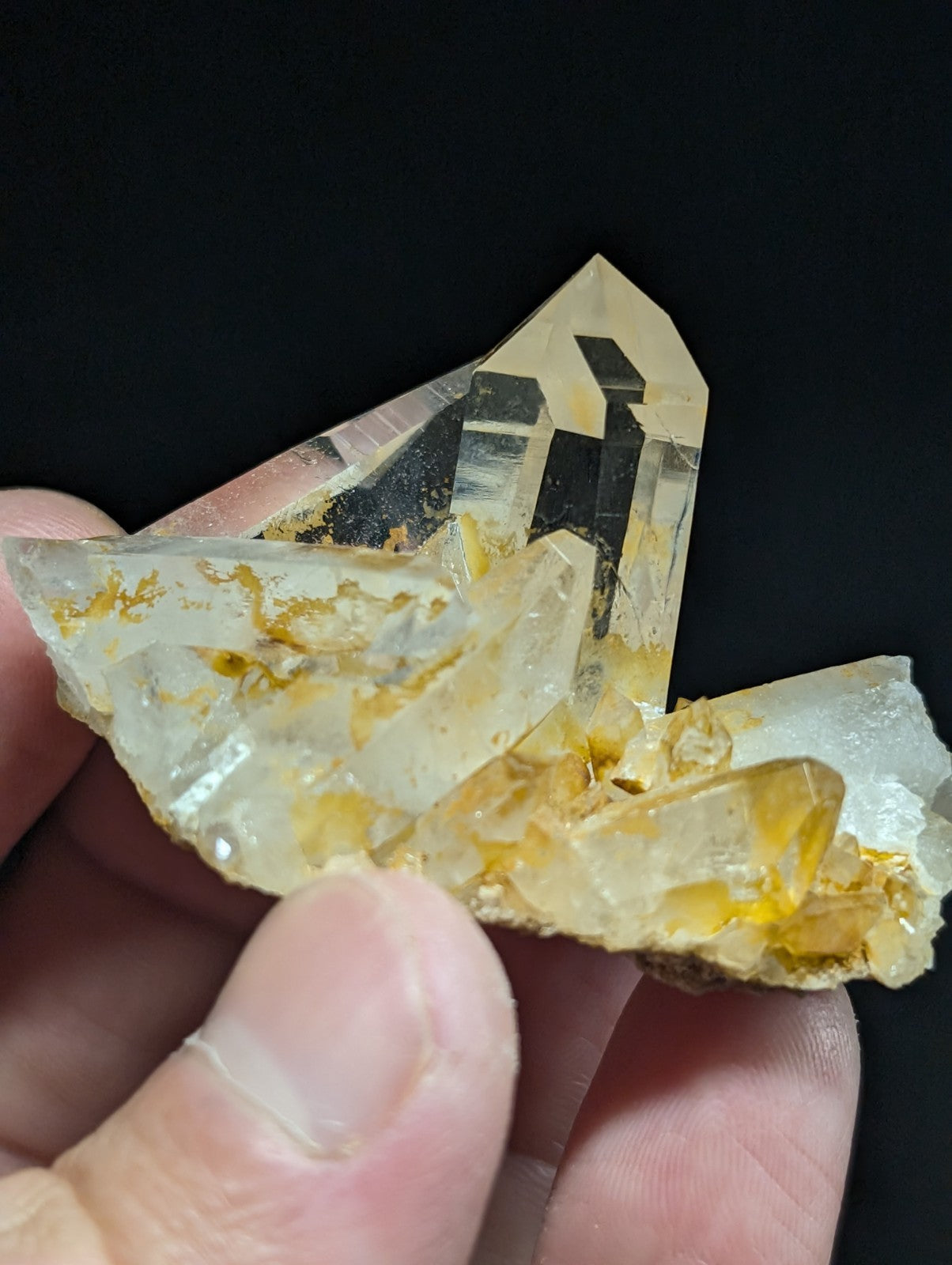 A translucent yellowish quartz crystal cluster with golden inclusions and sharp, angular facets.