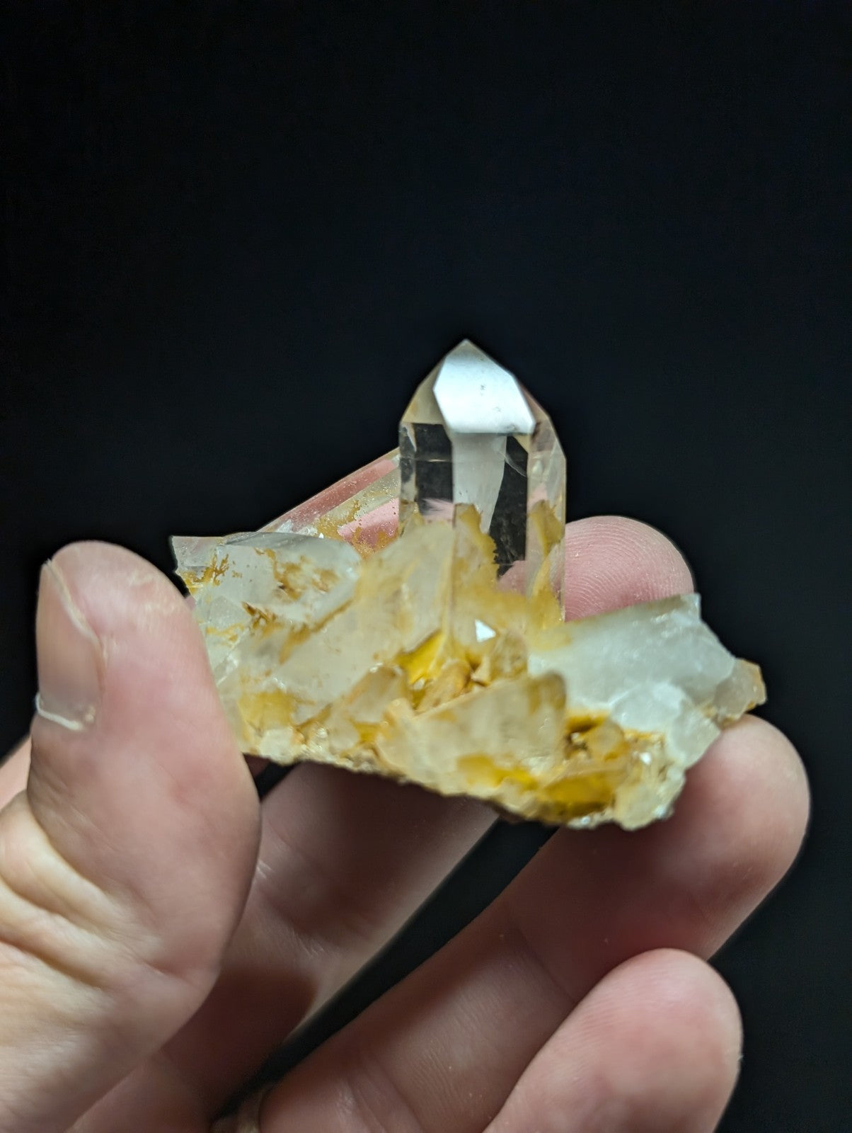 A translucent, golden-hued quartz crystal cluster with a prominent clear point.