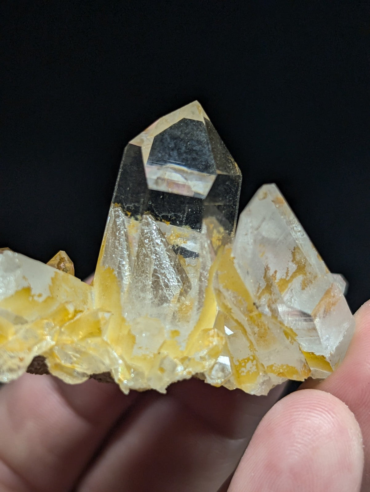 A translucent quartz crystal cluster with golden-yellow inclusions and sharp, faceted points.