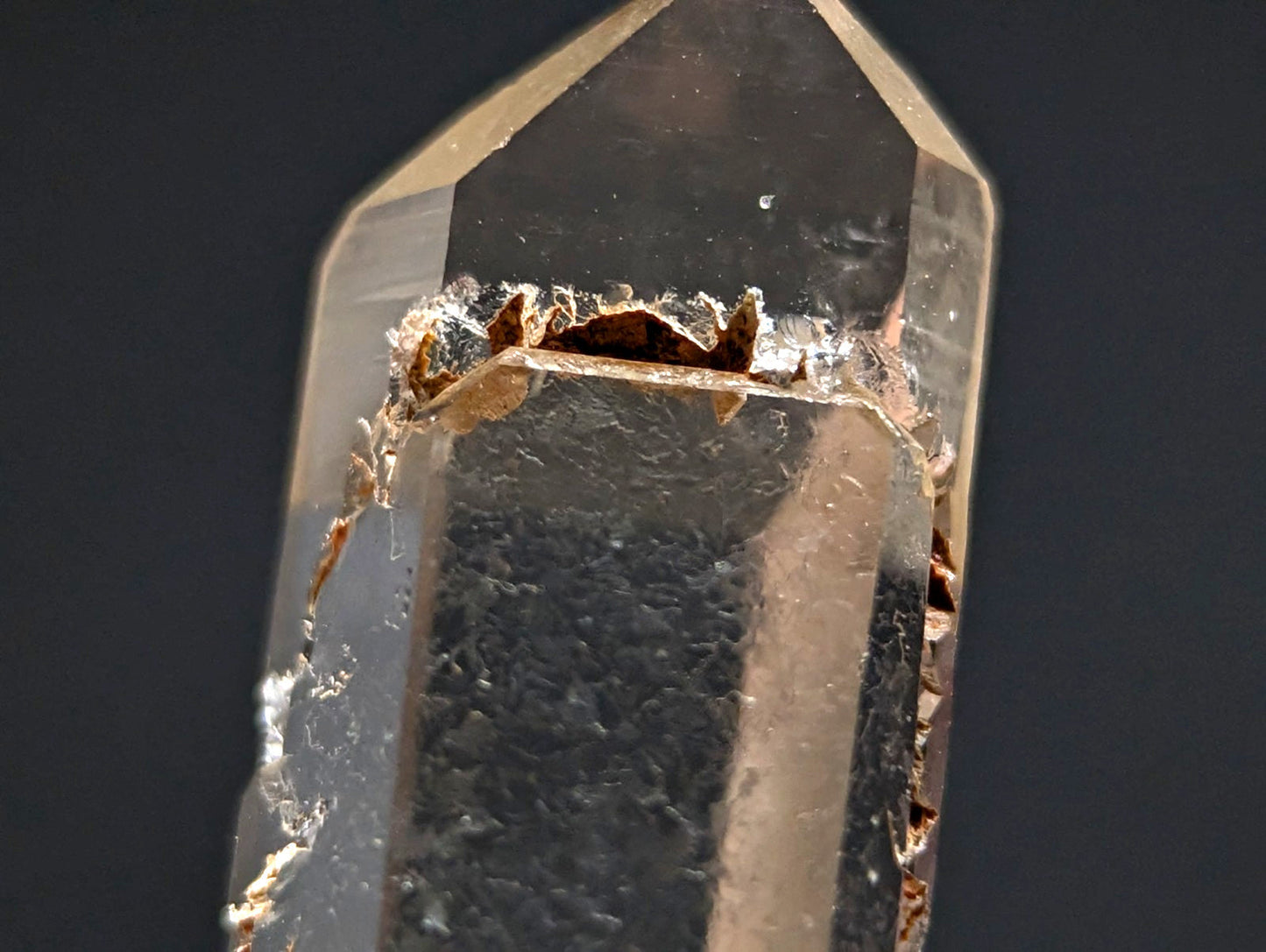 A clear quartz crystal with a faceted, geometric shape and visible internal inclusions.