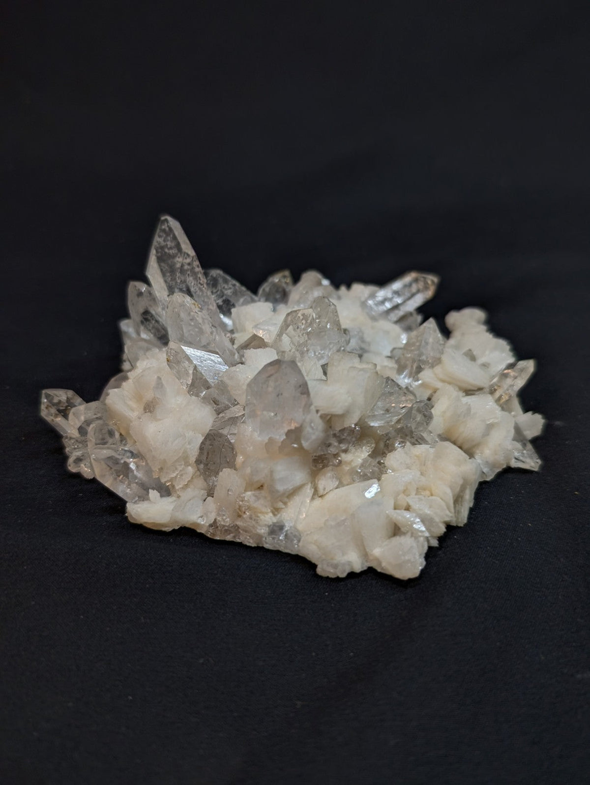 A translucent quartz crystal cluster with sharp, pointed formations and a mix of clear and milky white hues.