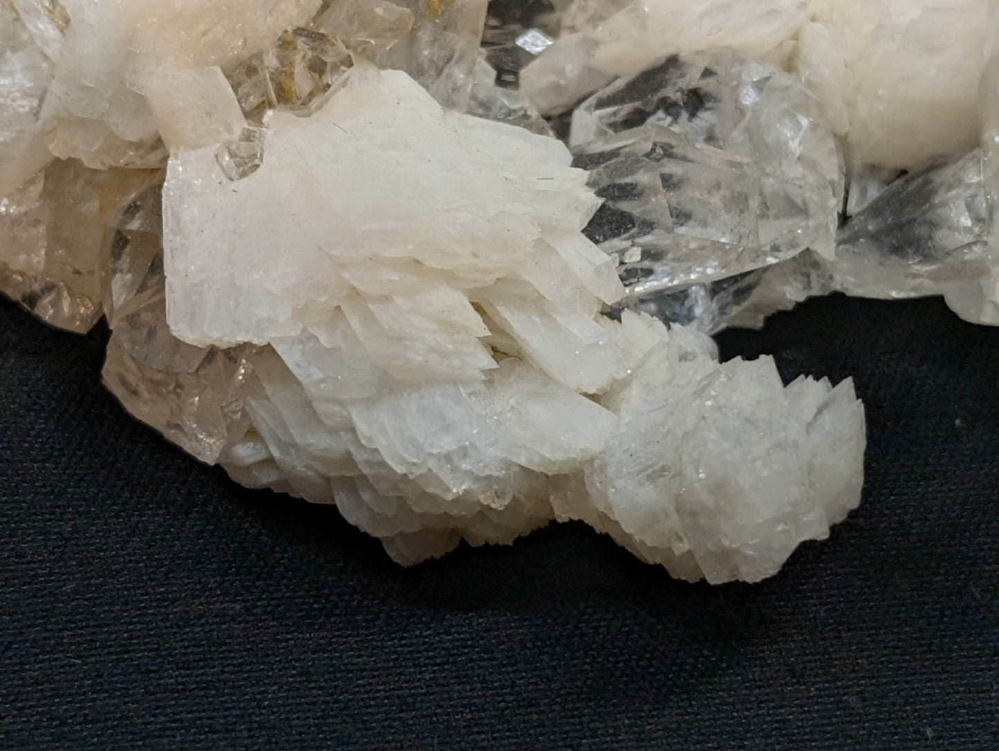 A cluster of translucent, crystalline quartz formations with varying shades from clear to pale yellowish-white.