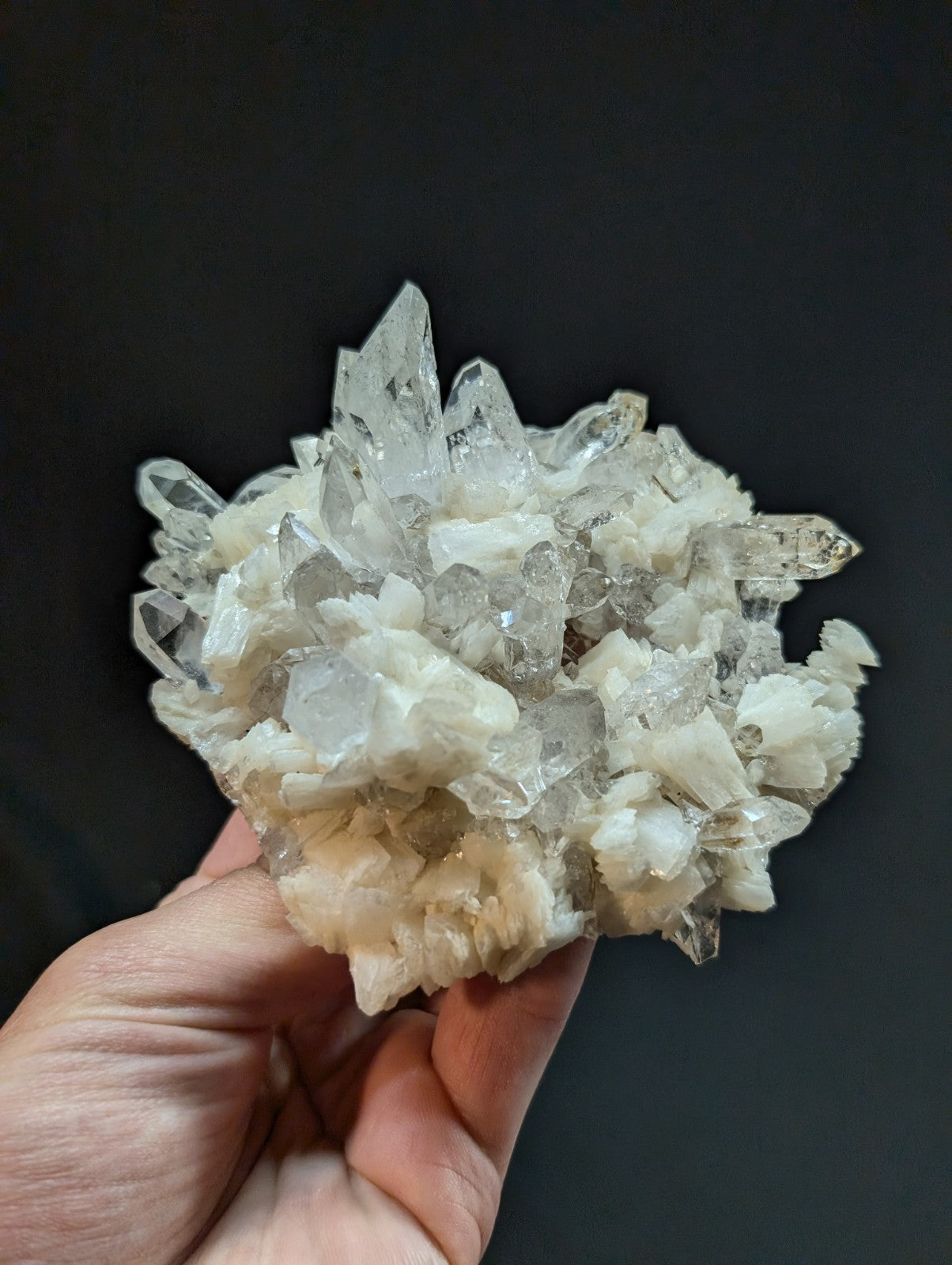 A translucent, crystalline quartz cluster with sharp, pointed facets and a mix of clear and milky white tones.