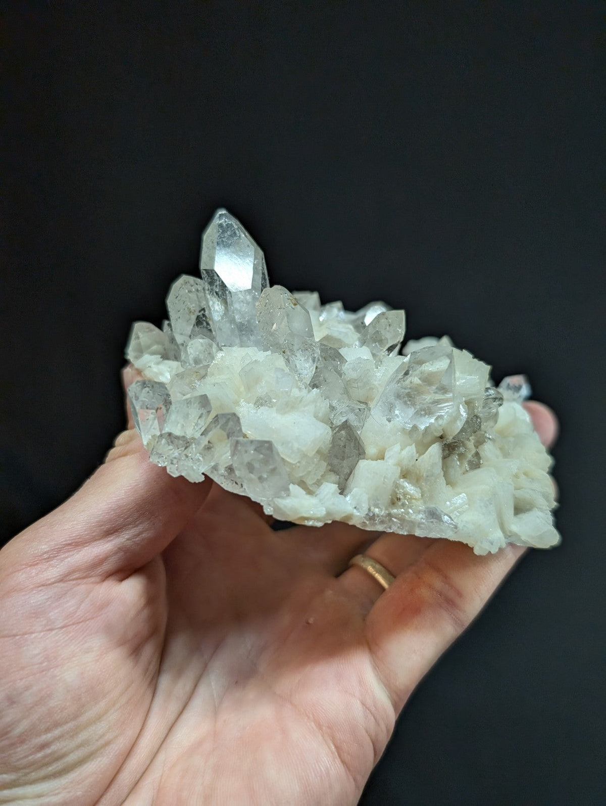 A translucent, clear quartz crystal cluster with sharp facets and a slightly cloudy base.