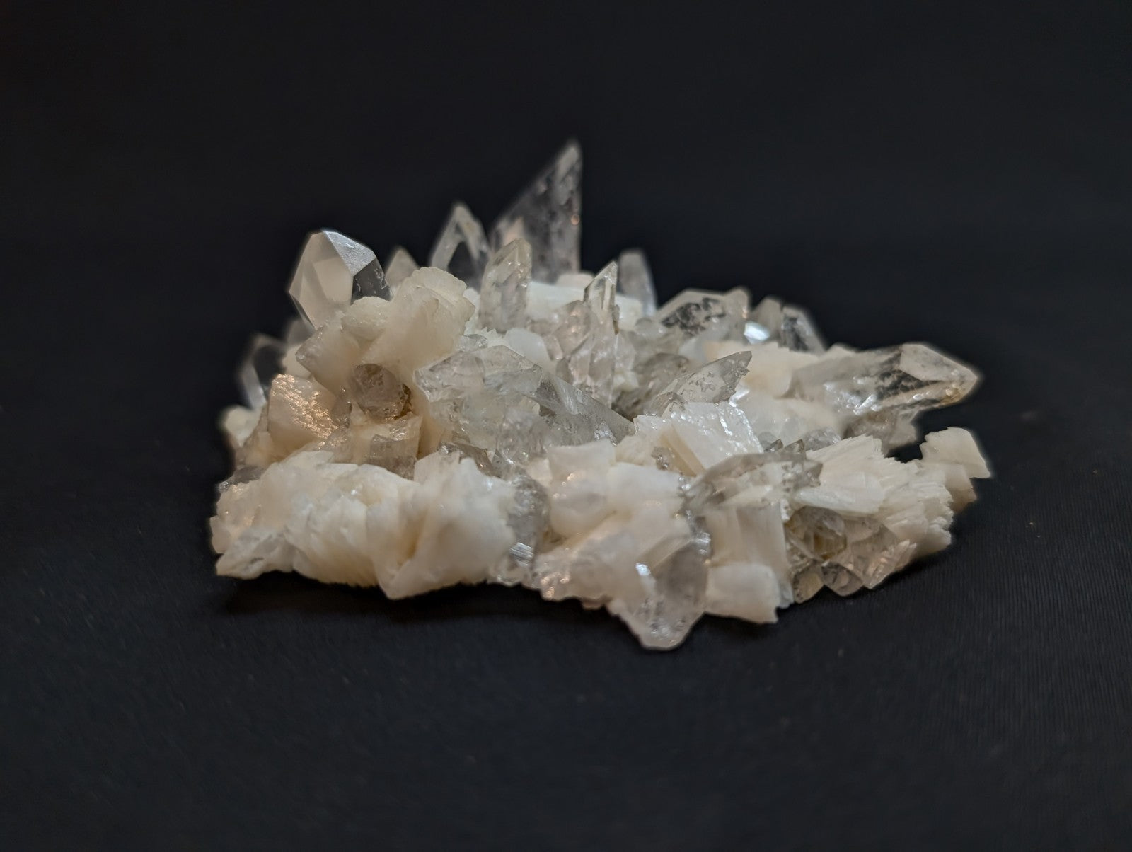 A cluster of translucent quartz crystals with sharp, pointed facets and a mix of clear and milky white hues.