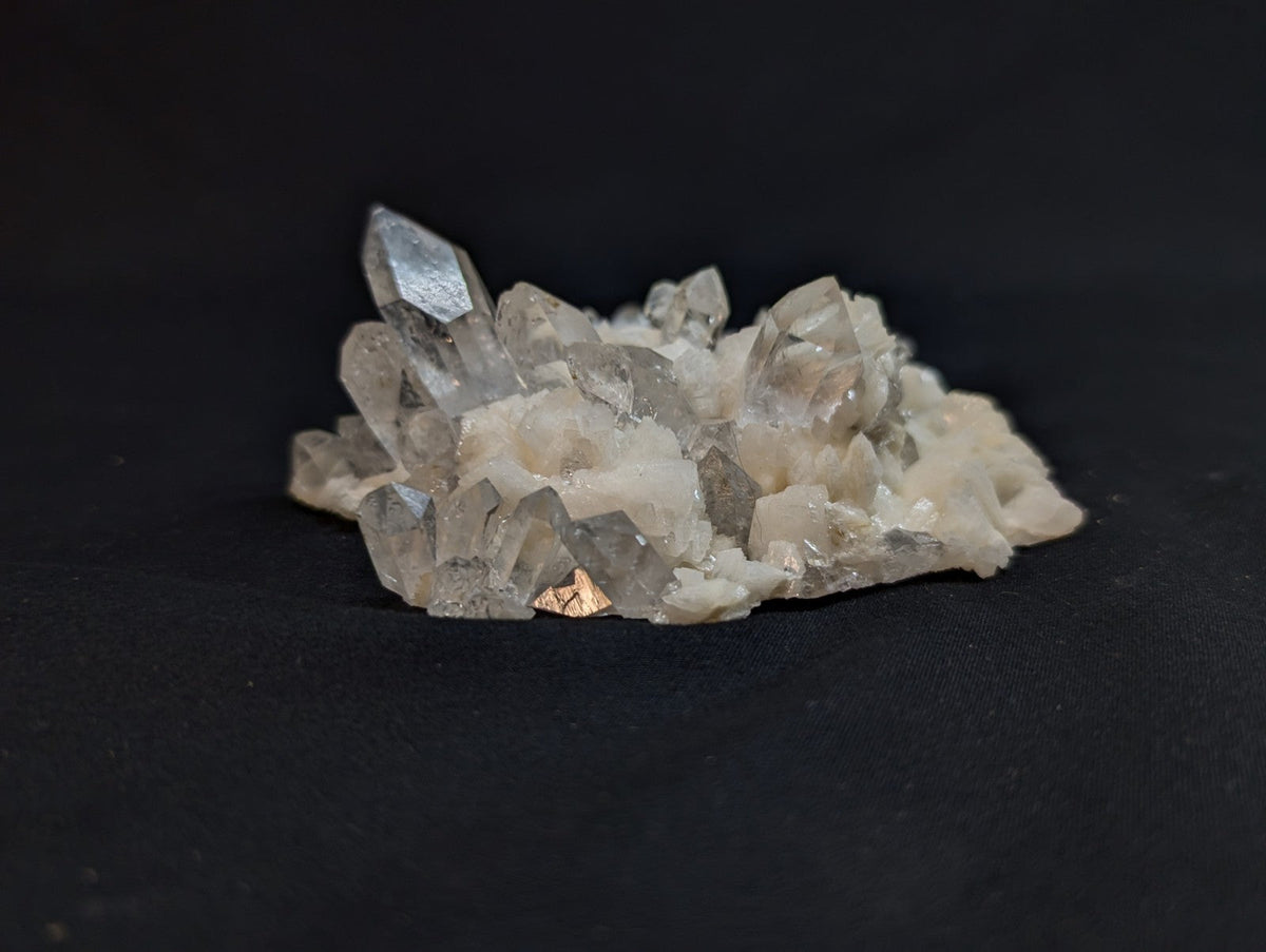 A translucent quartz crystal cluster with sharp, faceted points and a milky white base.