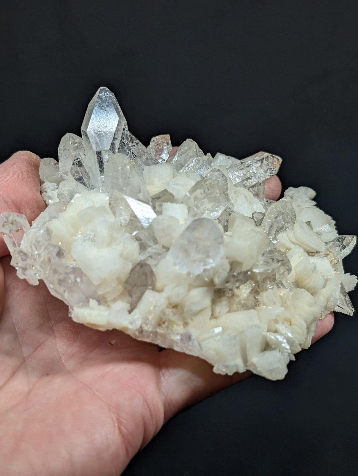 A translucent, crystalline quartz cluster with sharp, pointed facets and a mix of clear and milky white hues.
