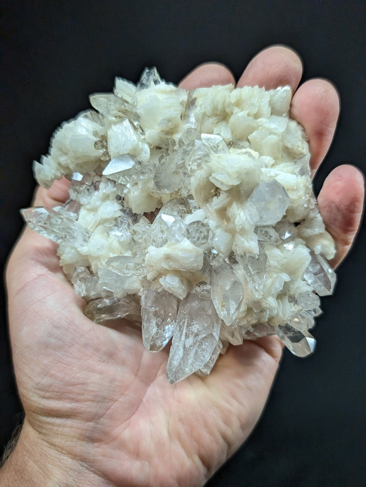 A cluster of translucent, crystalline quartz formations with a mix of clear and milky white hues.