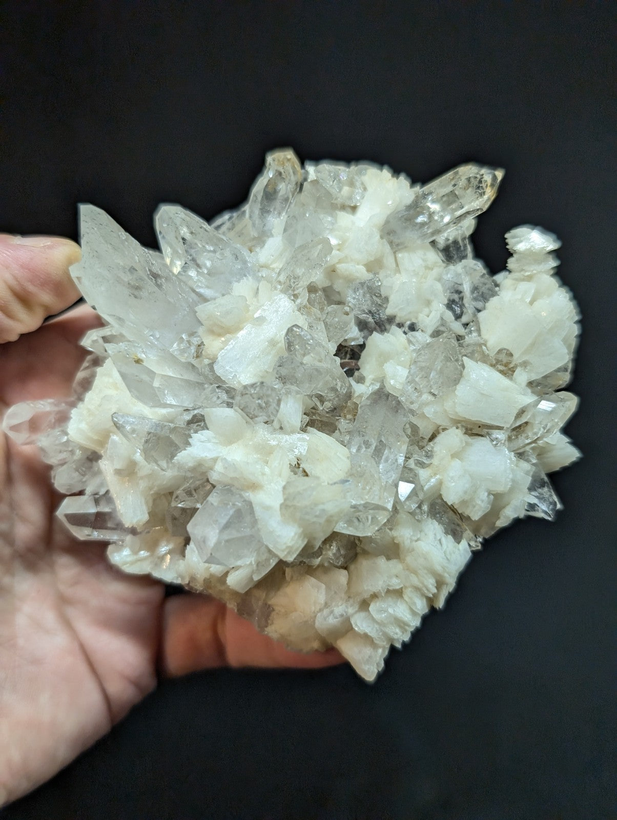 A translucent, crystalline quartz cluster with sharp, interlocking facets and a mix of clear and milky white tones.