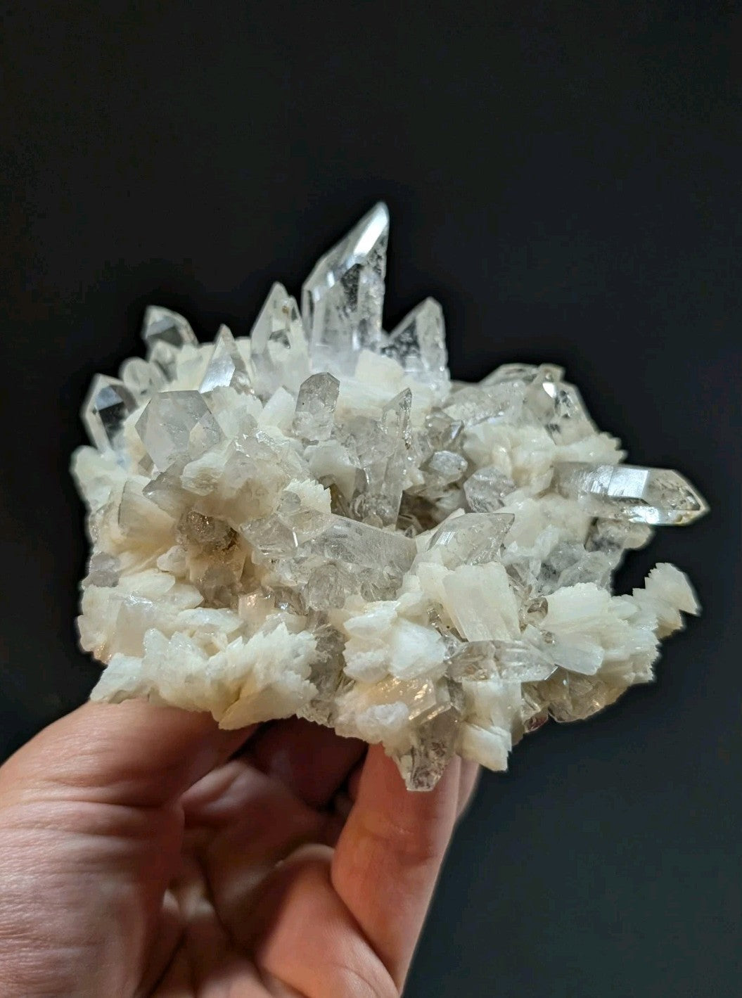 A cluster of clear, translucent quartz crystals with sharp points and a slightly milky white base.