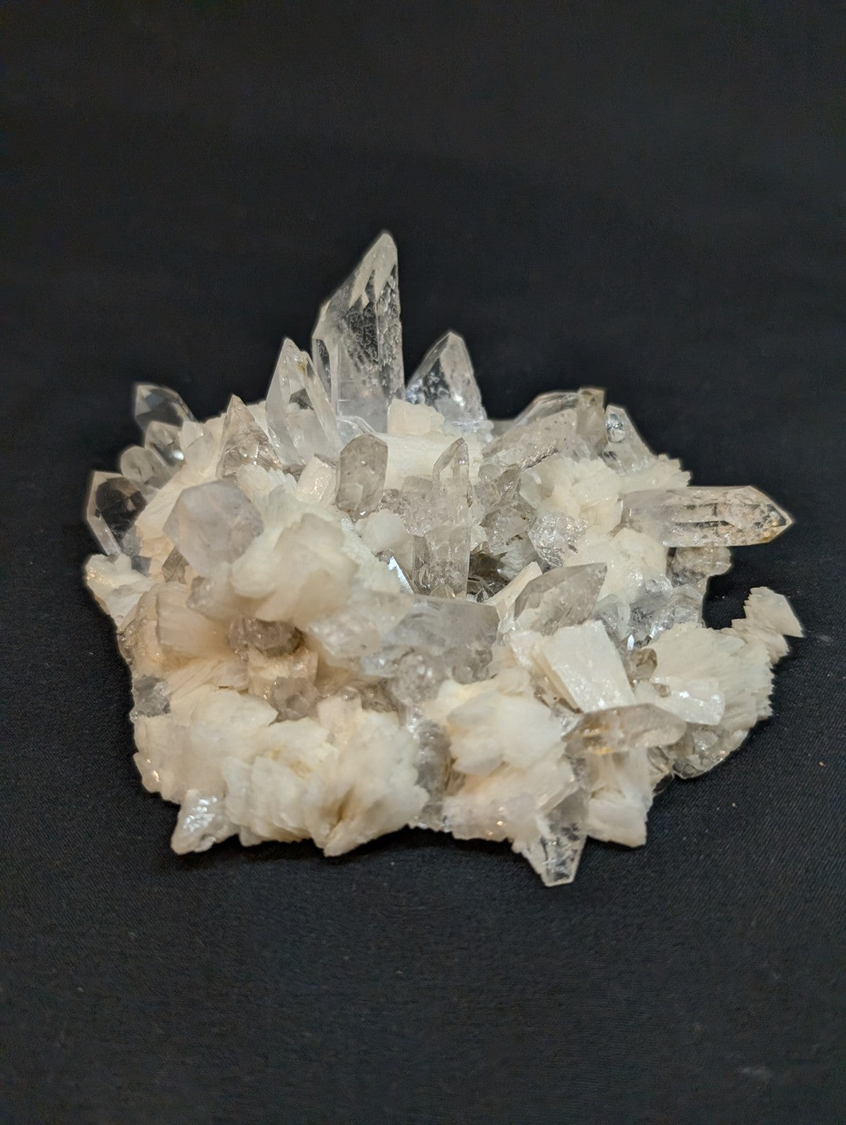 A translucent quartz crystal cluster with sharp, pointed facets and a mix of clear and milky white tones.