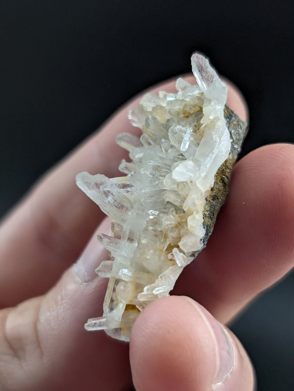 A translucent, crystalline quartz cluster with sharp, pointed facets and a pale yellowish tint.