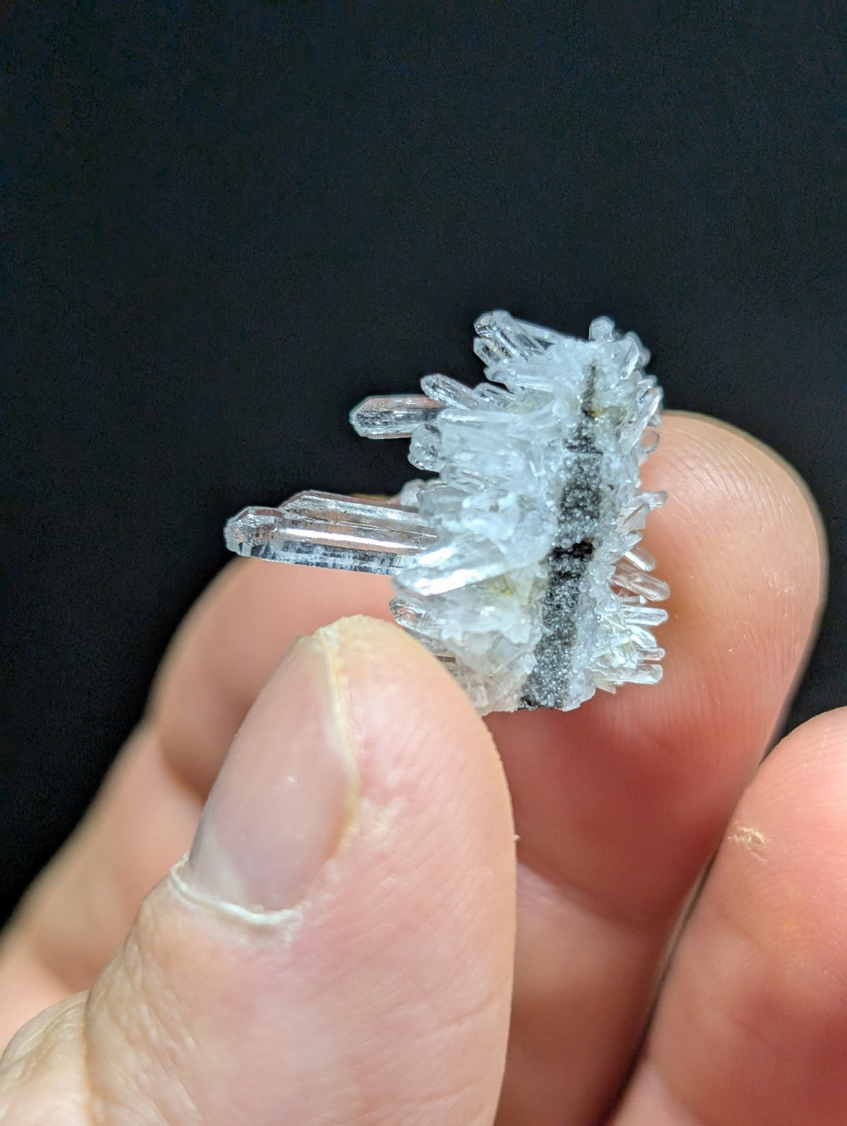 A translucent, crystalline mineral specimen with sharp, jagged facets and a central dark inclusion.