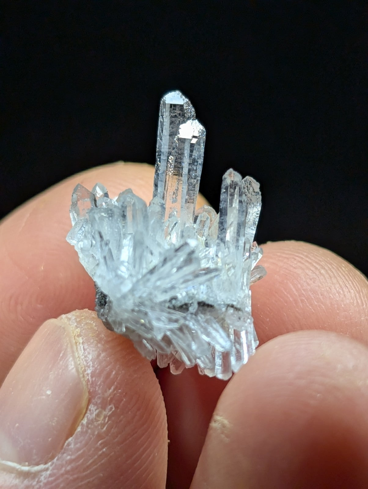 A translucent, clear quartz crystal cluster with sharp, pointed facets and a natural, branching growth pattern.