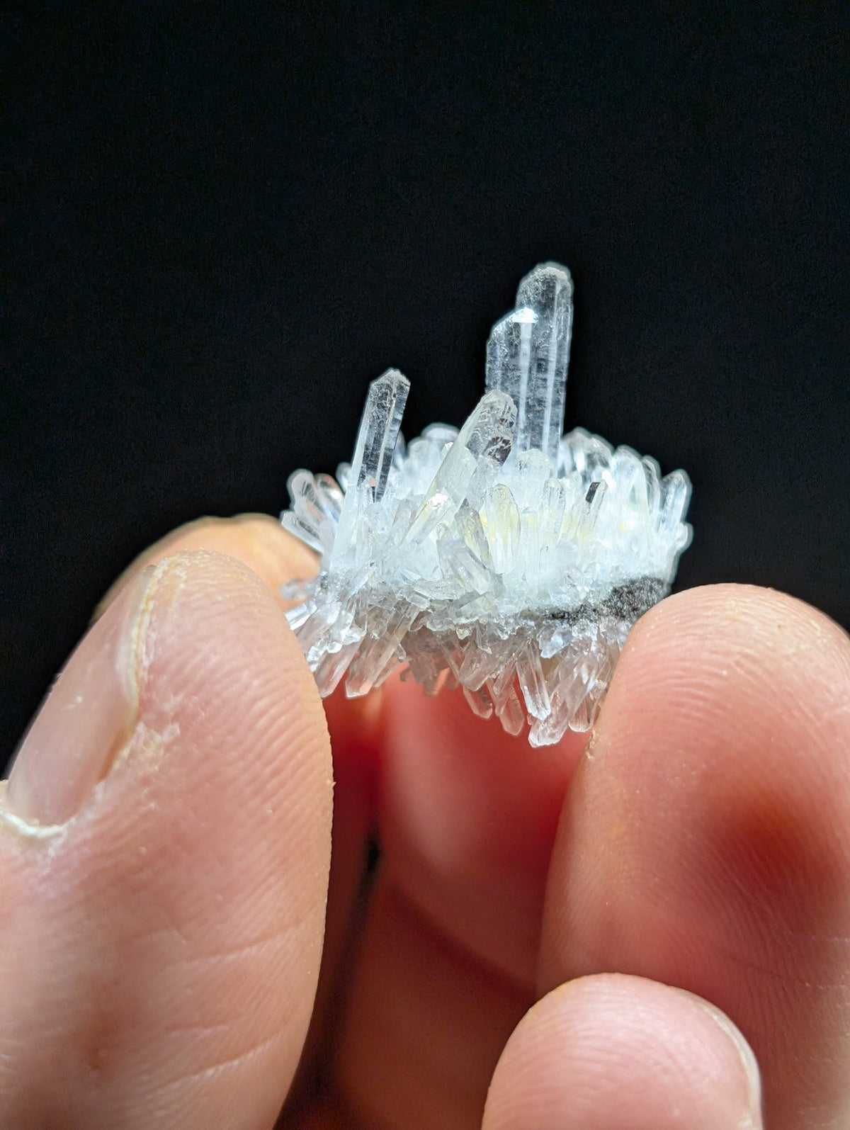 A clear, translucent quartz crystal cluster with sharp, pointed formations and a slightly frosted base.