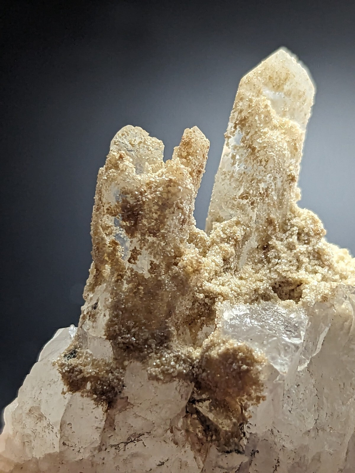 A translucent quartz crystal cluster with a mix of clear and milky white formations, accented by earthy brown mineral deposits.