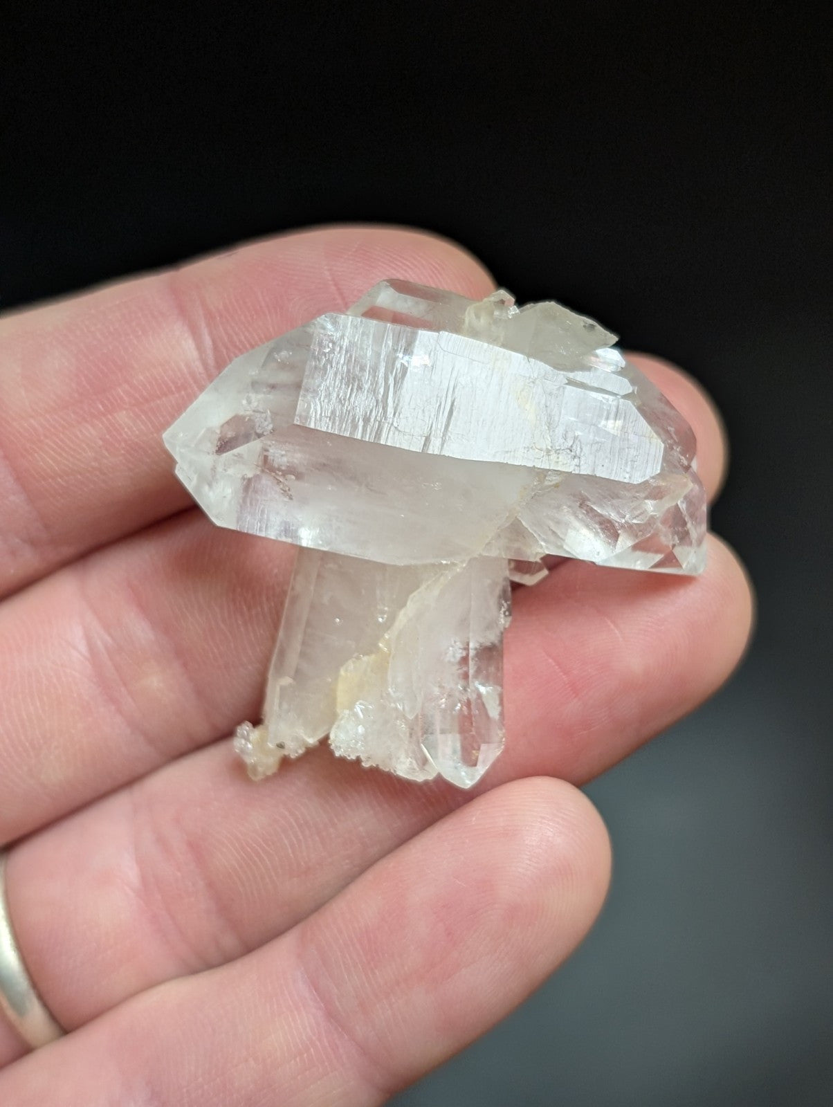 A translucent, clear quartz crystal cluster with a natural, jagged formation and subtle internal striations.
