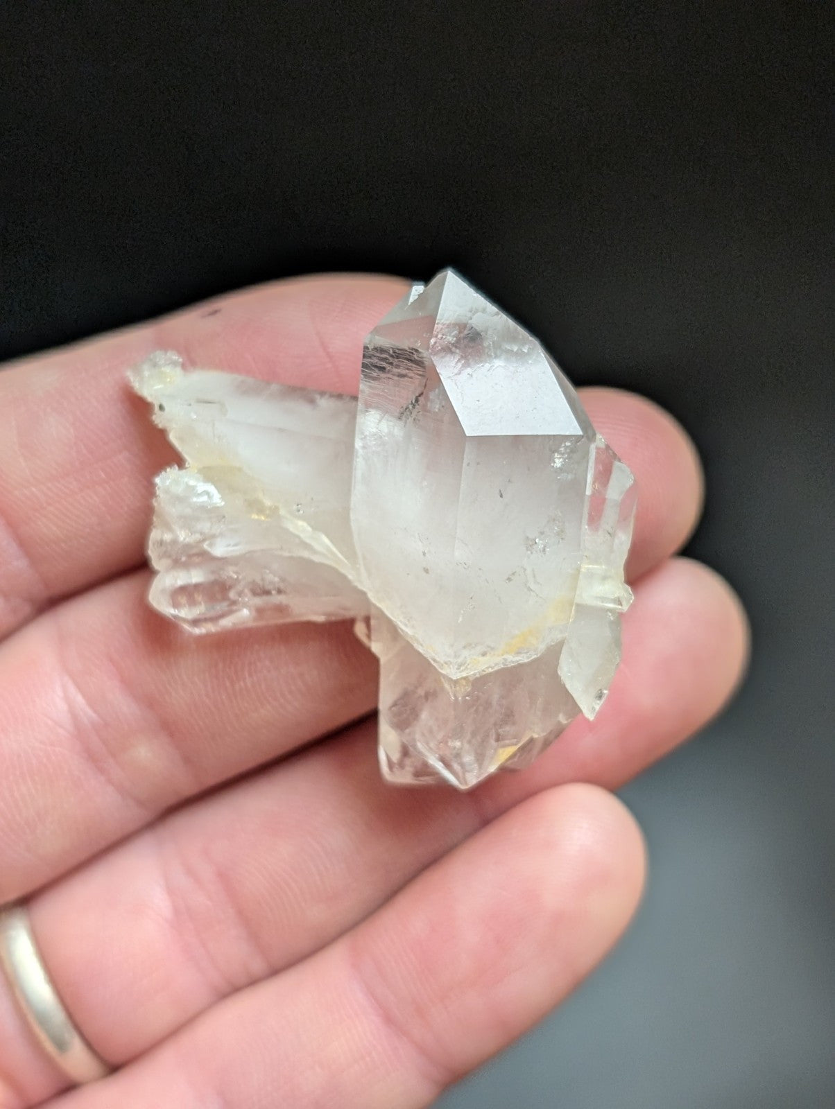 A translucent, clear quartz crystal cluster with sharp geometric facets and a slightly cloudy base.