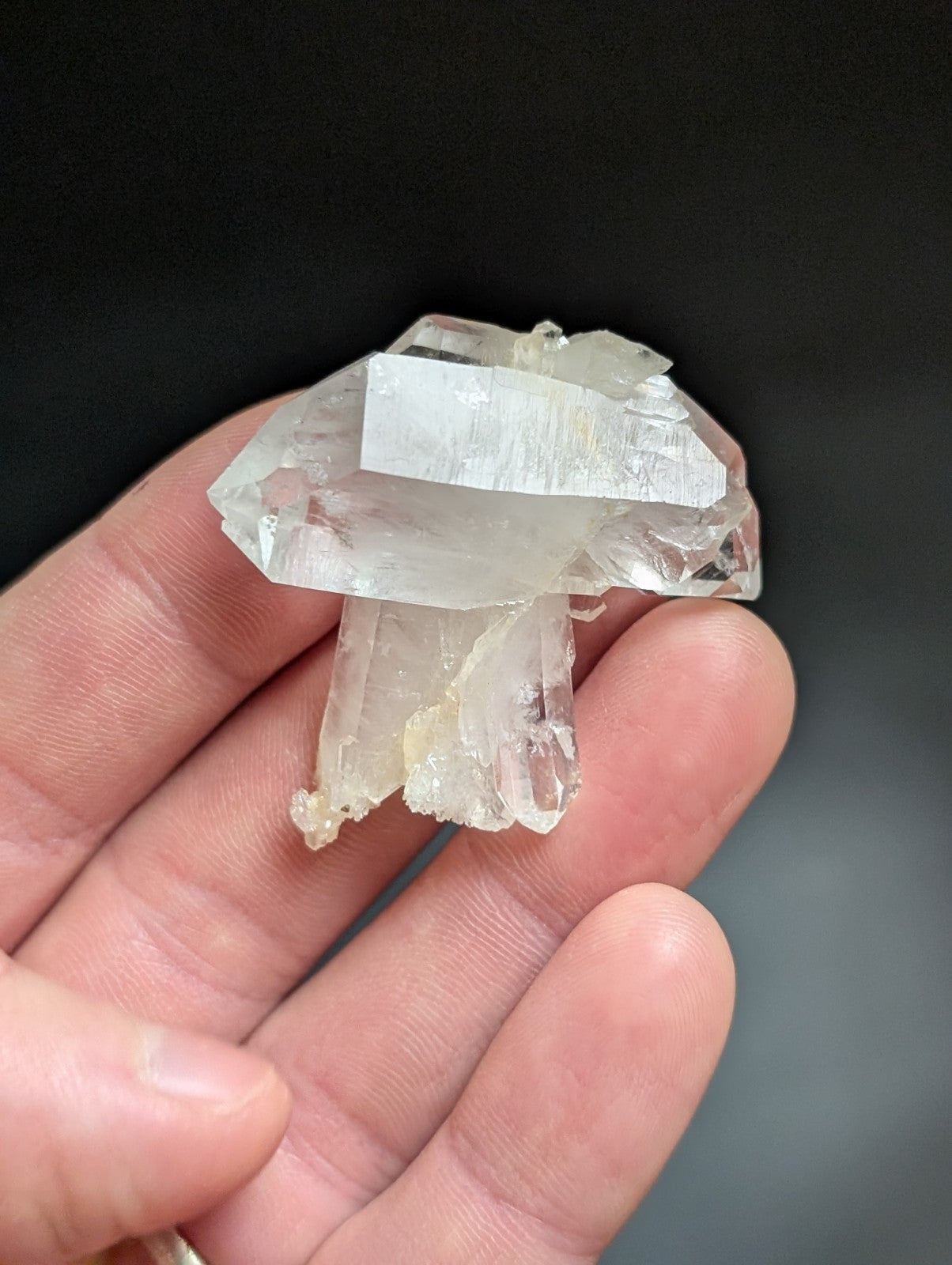 A translucent, clear quartz crystal cluster with a natural, jagged formation and subtle internal striations.
