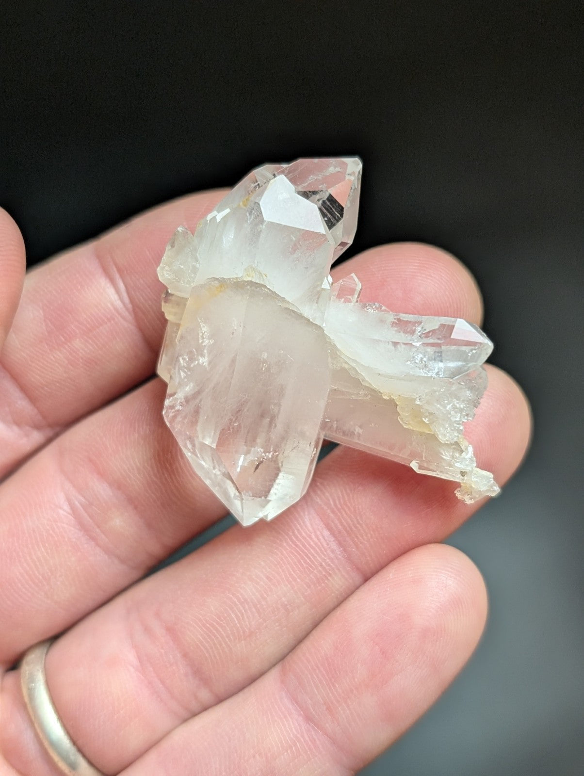 A translucent, clear quartz crystal cluster with sharp facets and a slightly milky appearance.