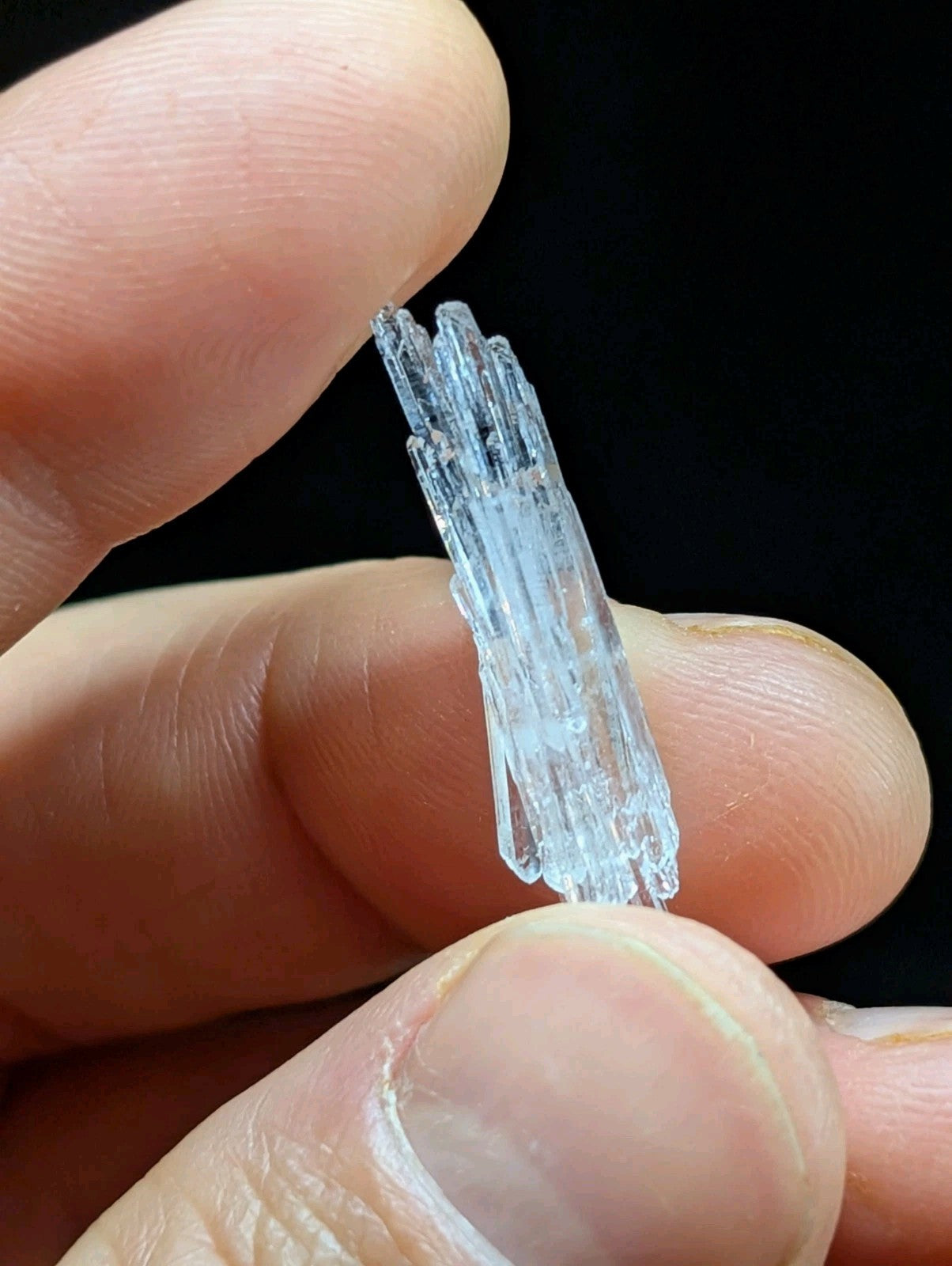 A translucent blue crystal cluster with multiple slender, interlocking prismatic formations.