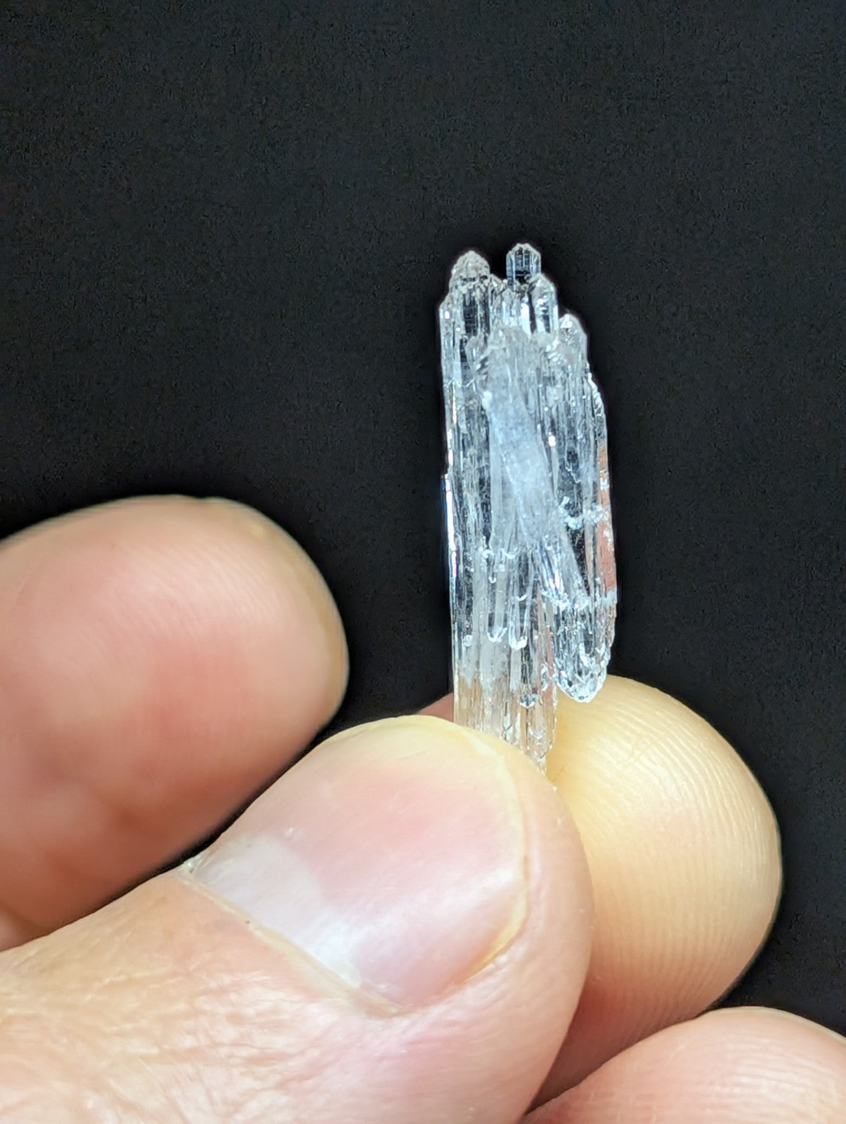 A translucent, clear crystal cluster with multiple pointed facets and a slightly frosted appearance.