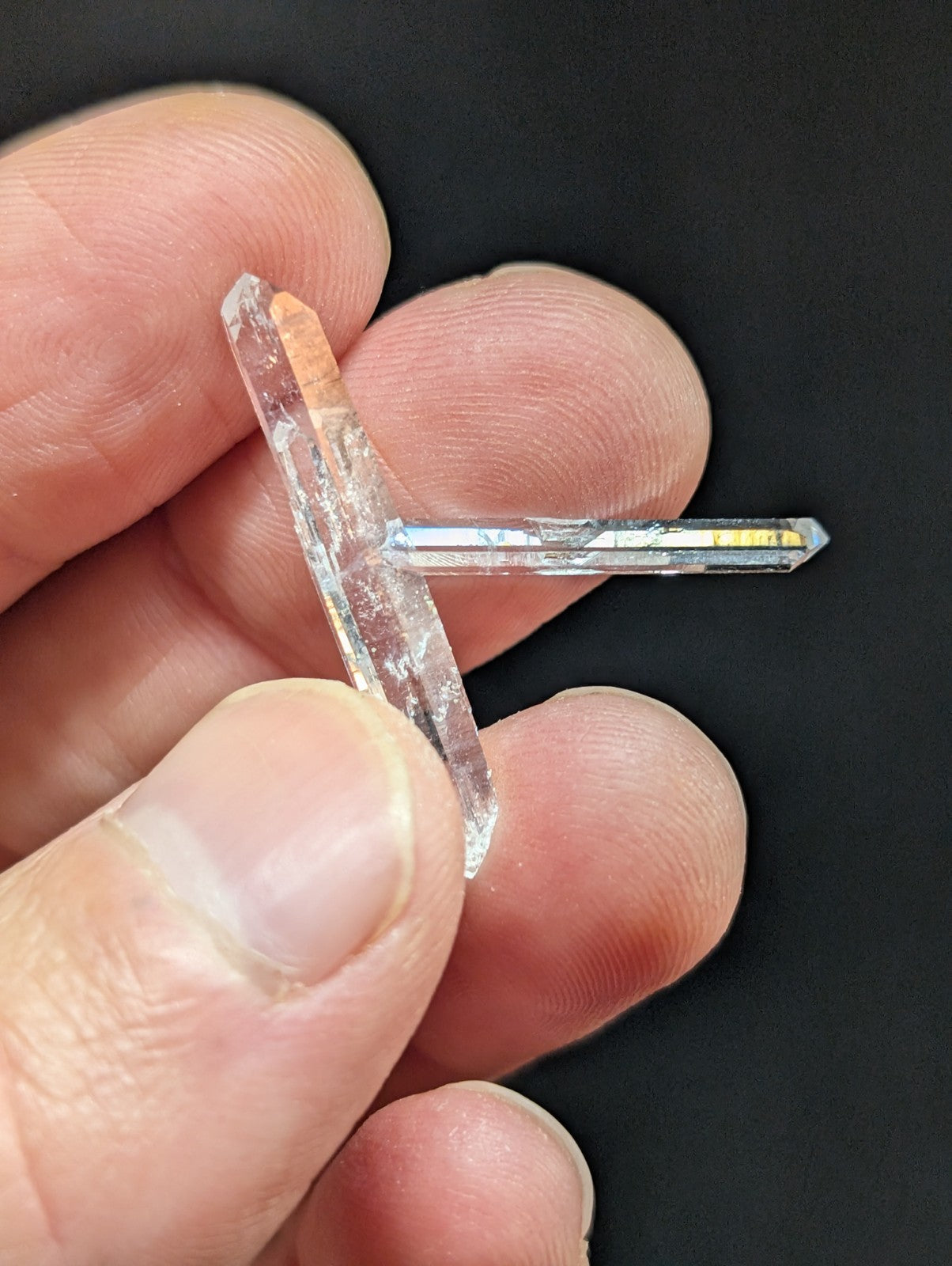 A clear, translucent quartz crystal with a natural t-shaped formation and subtle internal inclusions.