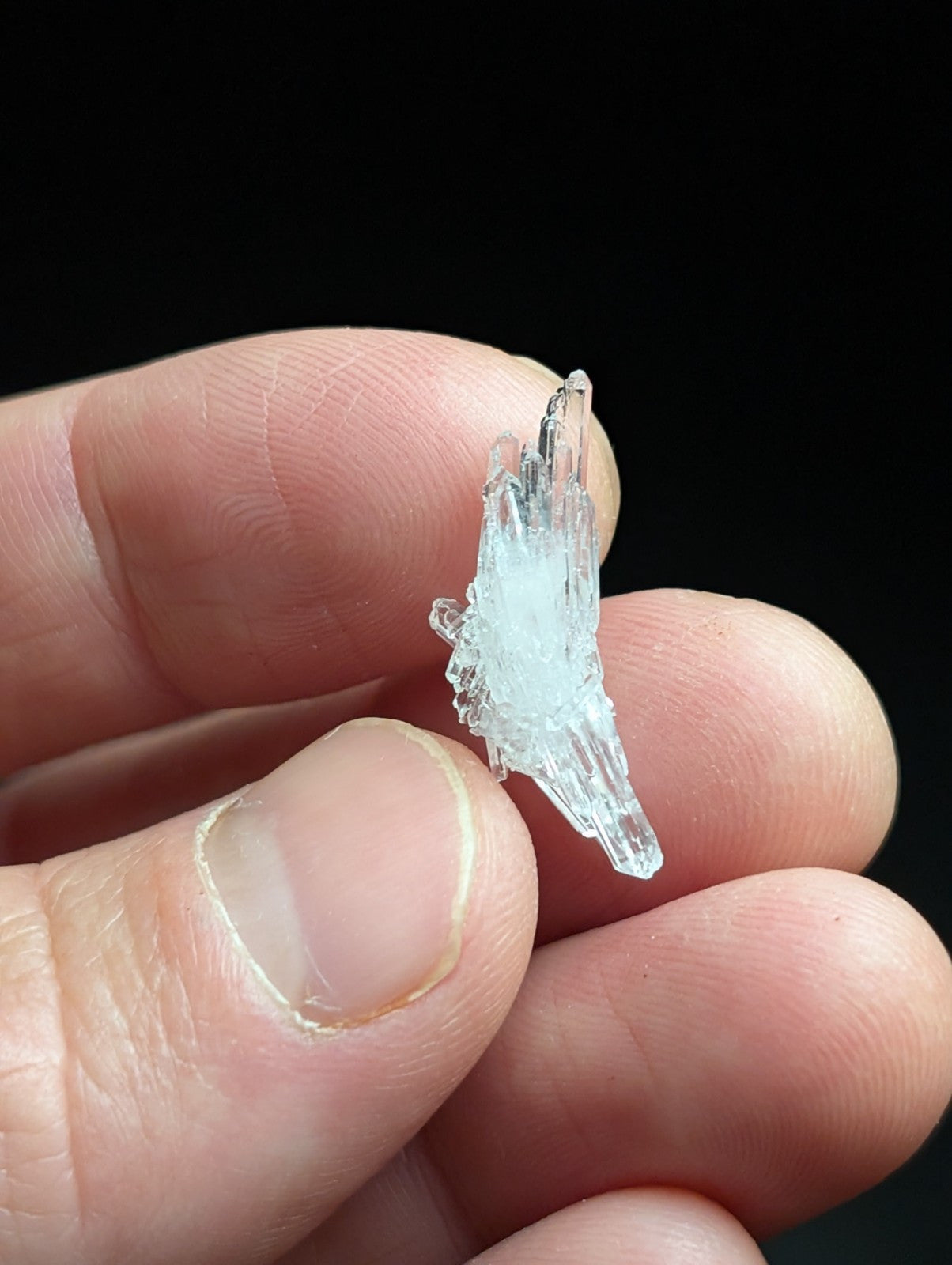 A translucent, crystalline mineral specimen with sharp, jagged edges and a pale blue tint.