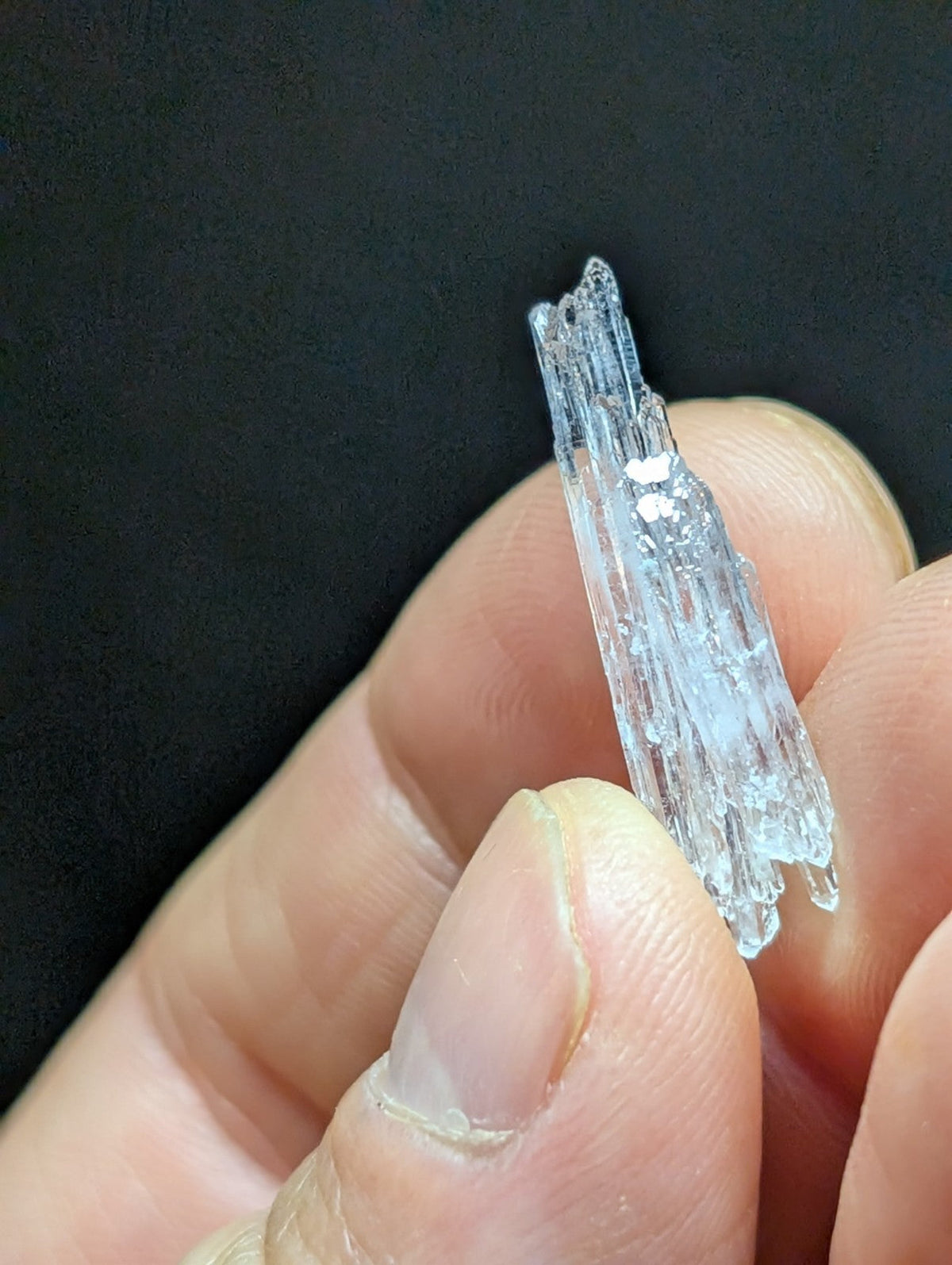 A translucent, crystalline mineral specimen with jagged edges and internal striations.