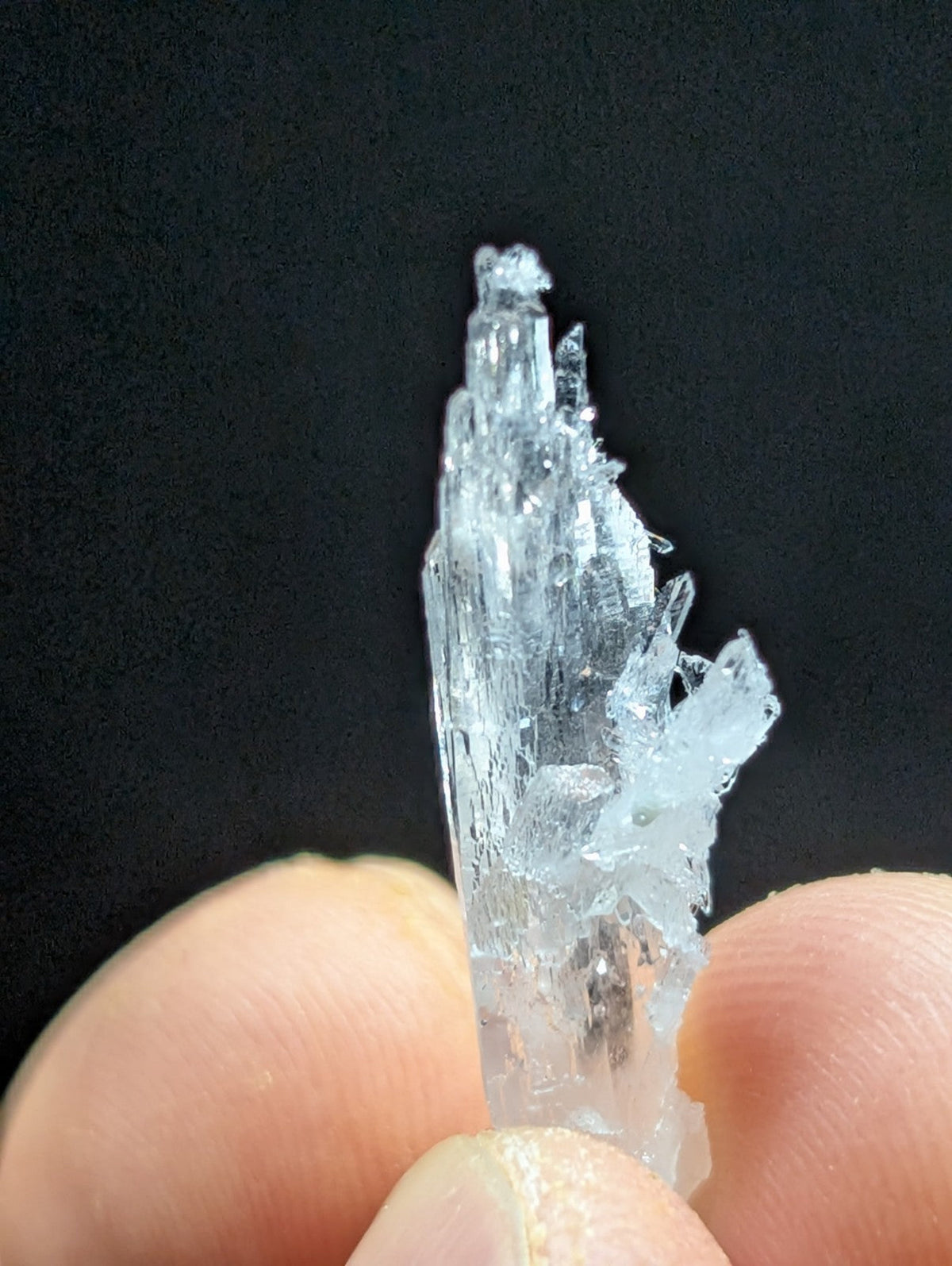 A translucent, crystalline mineral specimen with sharp, jagged edges and a clear, glassy appearance.