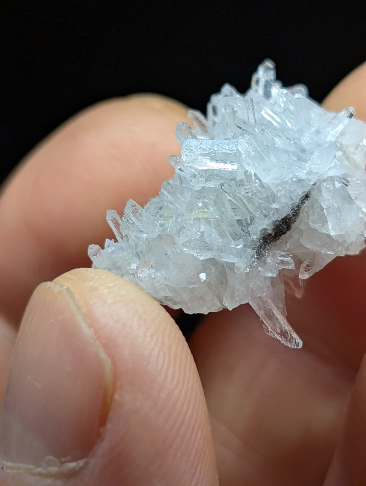 A translucent, crystalline mineral specimen with sharp, interlocking facets and a pale blue tint.