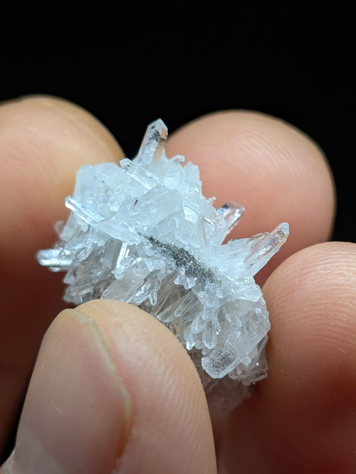A translucent, crystalline mineral specimen with sharp, interlocking facets and a pale blue tint.